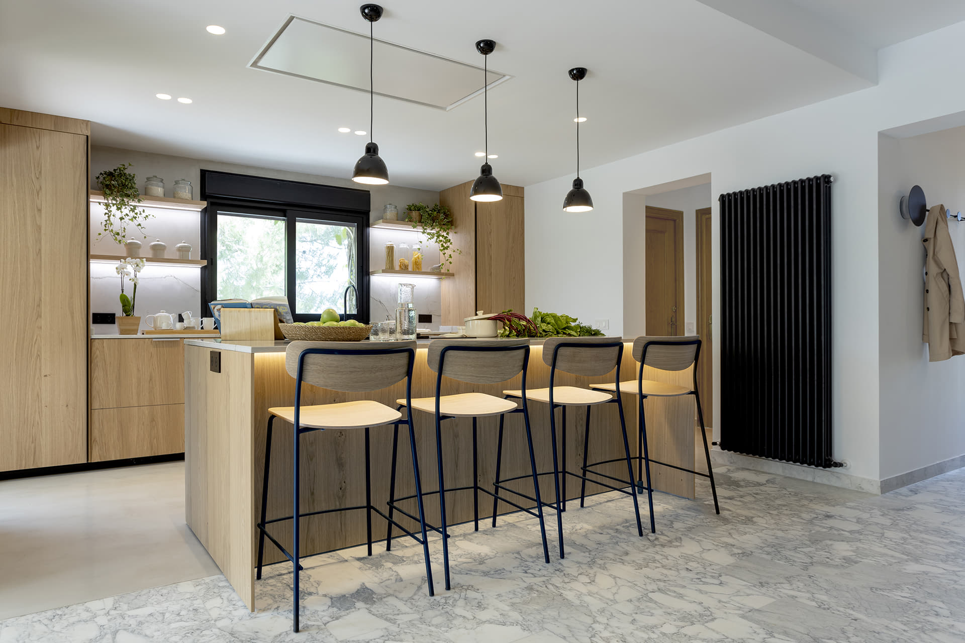 Cocina en madera en paralelo con isla y taburetes.