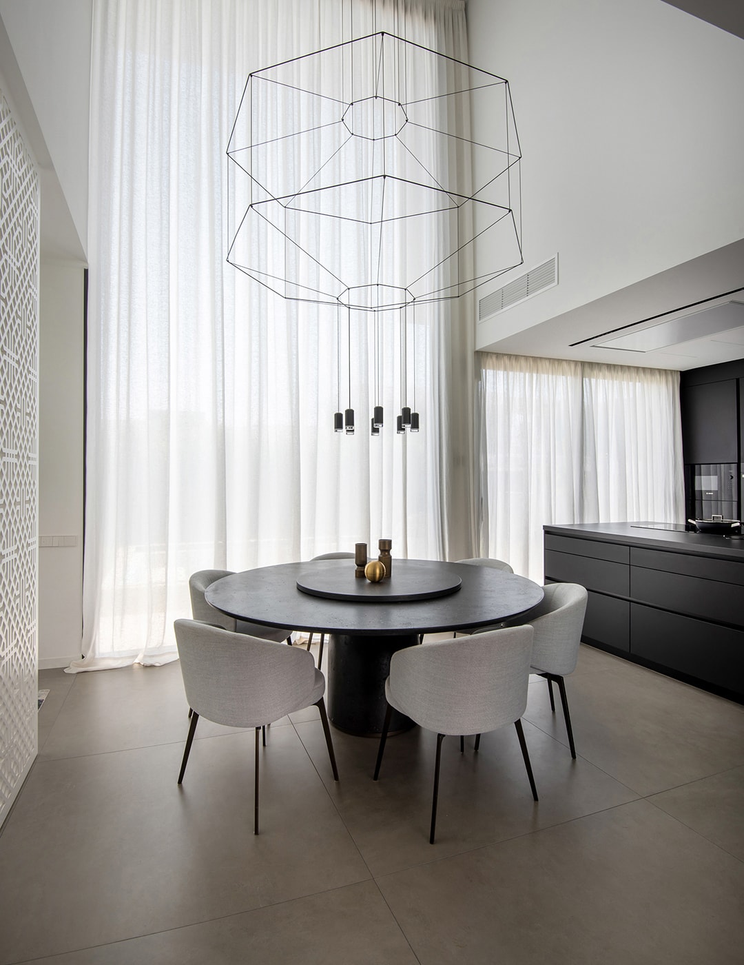 Sala de jantar com móveis pretos junto a uma cozinha Santos.