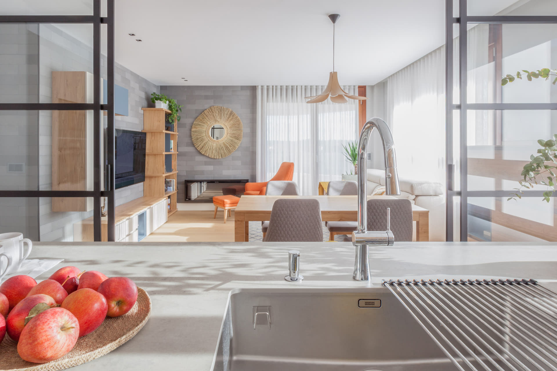 Isla de cocina abierta al salón comedor con encimera blanca diseñada por Santos.