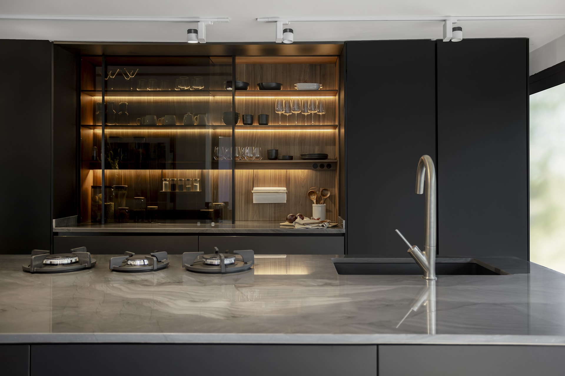 Zwarte keuken met wandkasten in brede lineaire opstelling in de showroom van Santos keukens in Mexico-Stad.