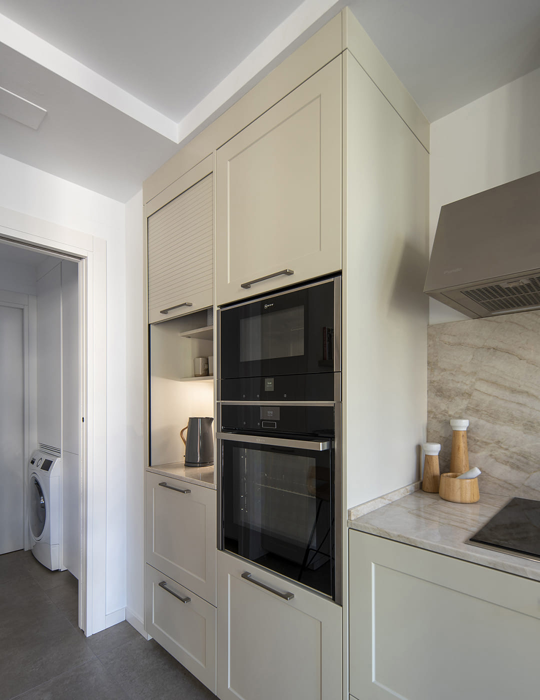 Armarios de cocina en columna con electrodomésticos integrados en una cocina Santos blanca.