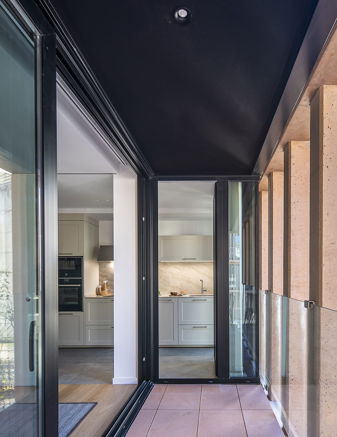 Galería de acceso a una cocina abierta al salón diseñada por Santos.
