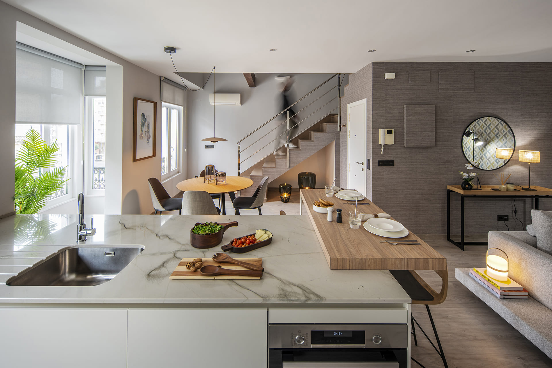 Península de cocina con mesado en acabado de madera Olmo Claro en un proyecto de Cocina Santos.