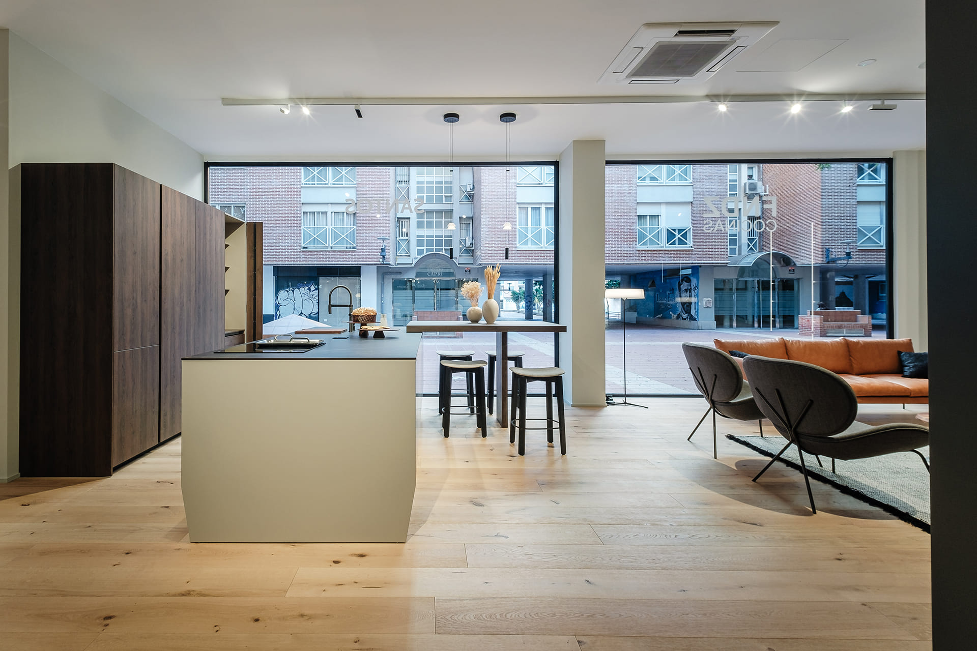 Cocina gris abierta a sala de estar en el nuevo showroom de Cocinas Santos en Murcia.