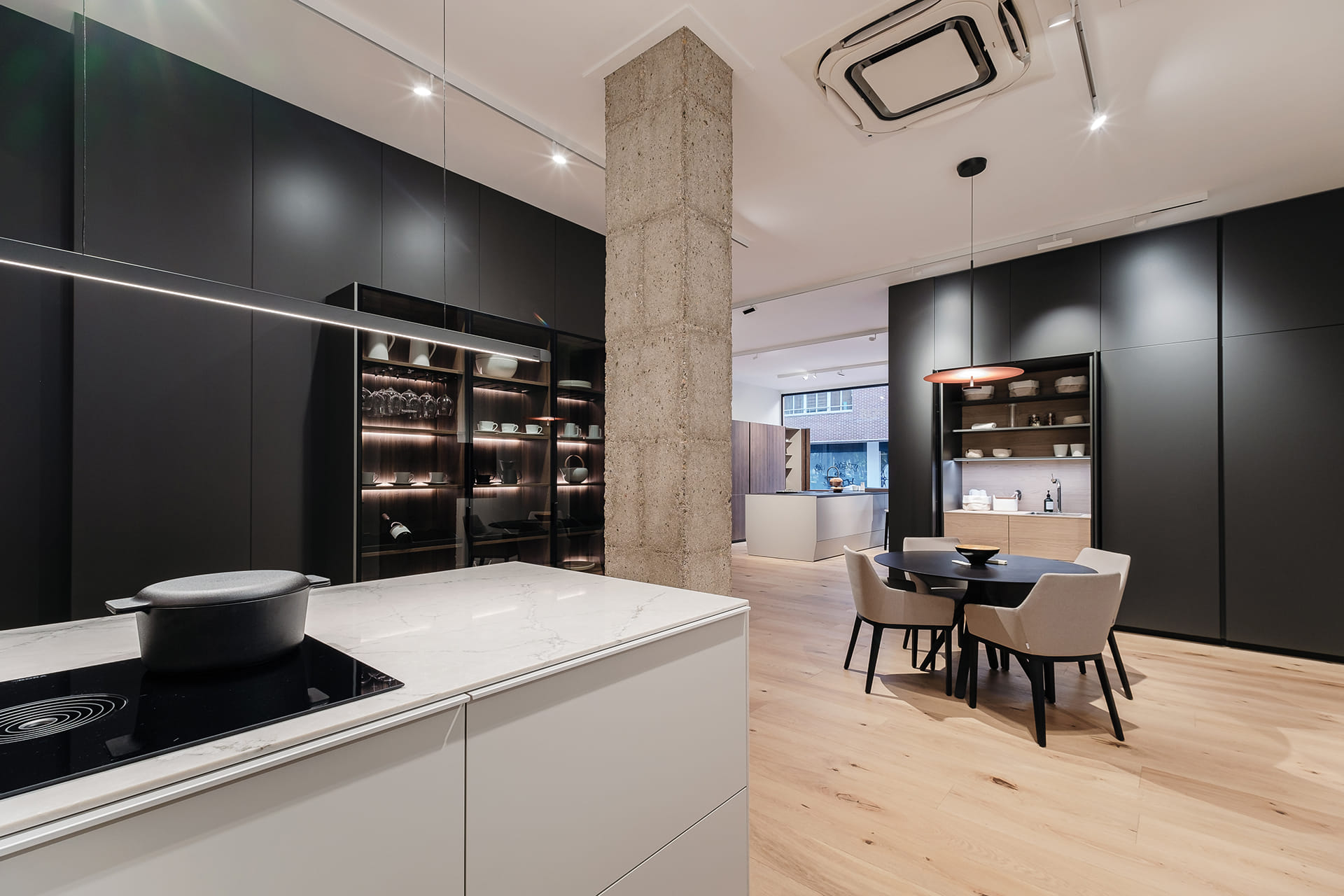 Cocina con península y vitrinas en Roble Claro Sincro en la tienda de Cocinas FNDZ.