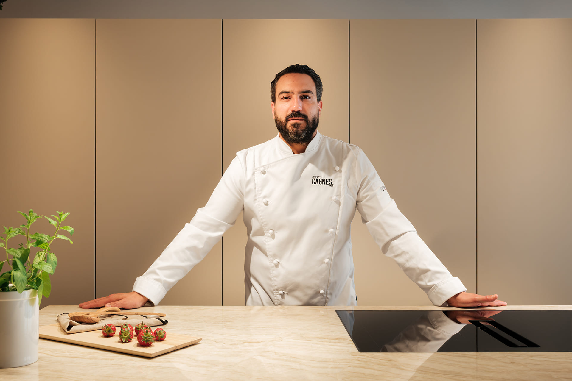 O chef Jeffrey Cagnes posa na ilha de cozinha concebida pela Santos Paris.