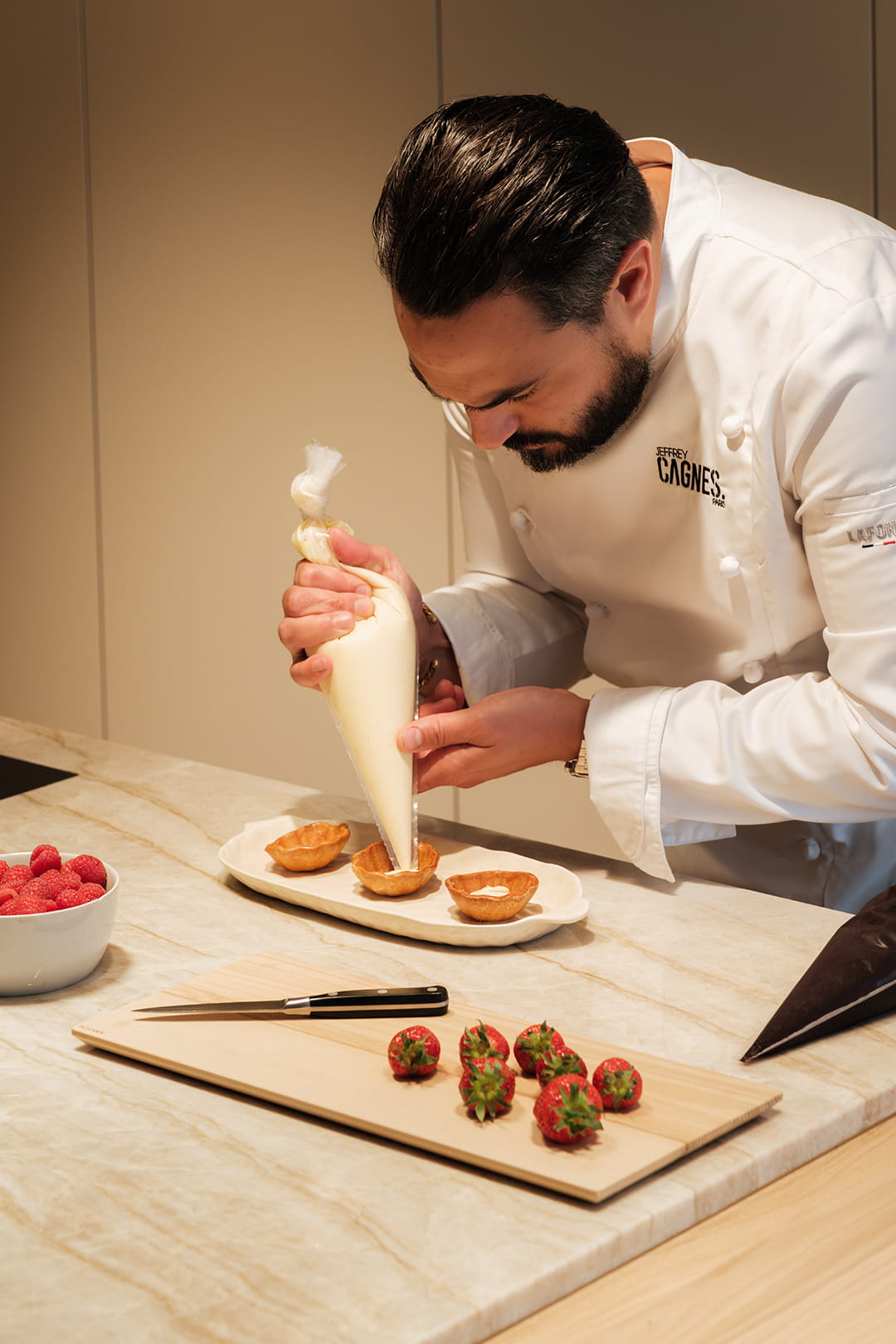 O chef Jeffrey Cagnes prepara uma sobremesa numa ilha de cozinha concebida pela eba Haussmann.