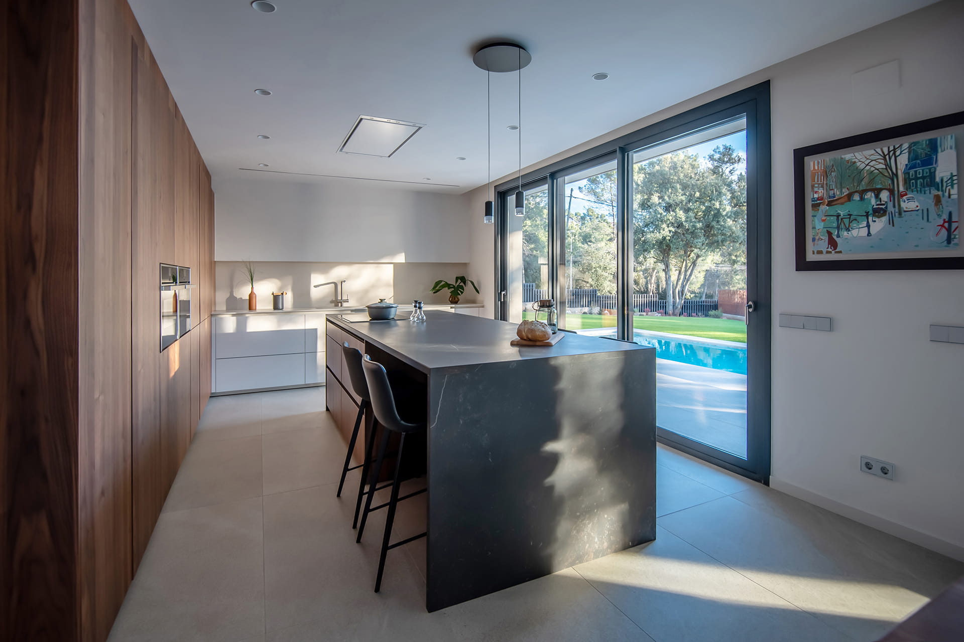 Cocina blanca y madera con isla central diseñada por Cocinas Santos.