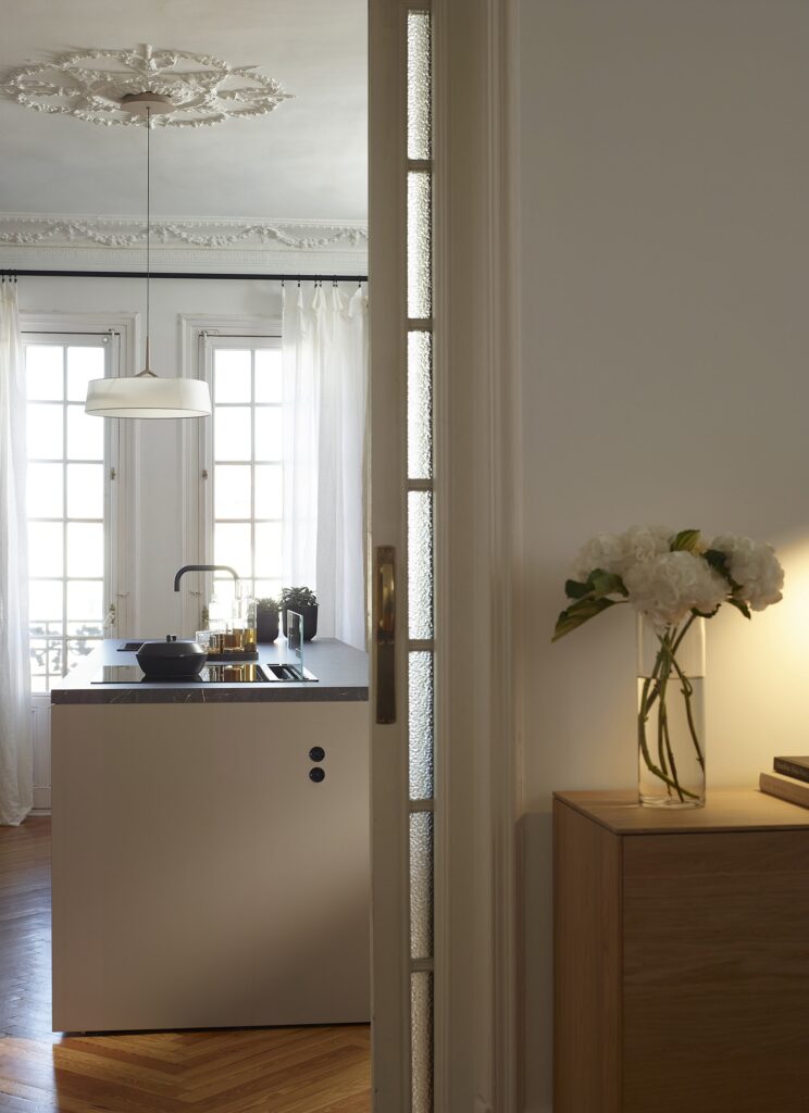 Open-plan grey kitchen with island connected to an entrance hall fitted out with a Santos sideboard unit