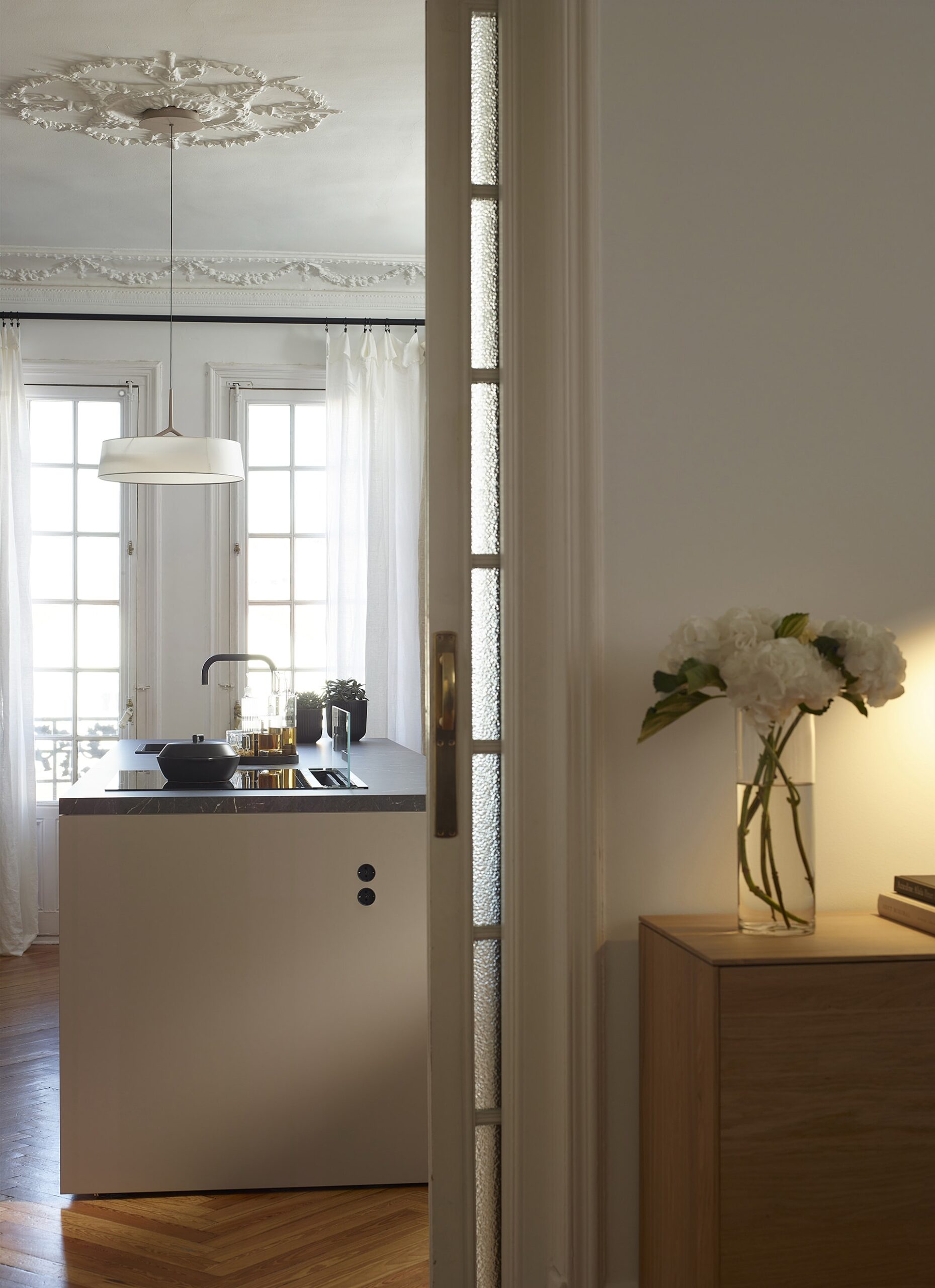 Cozinha cinza aberta com ilha comunicada com um hall de entrada equipado como un aparador da linha Living da Santos