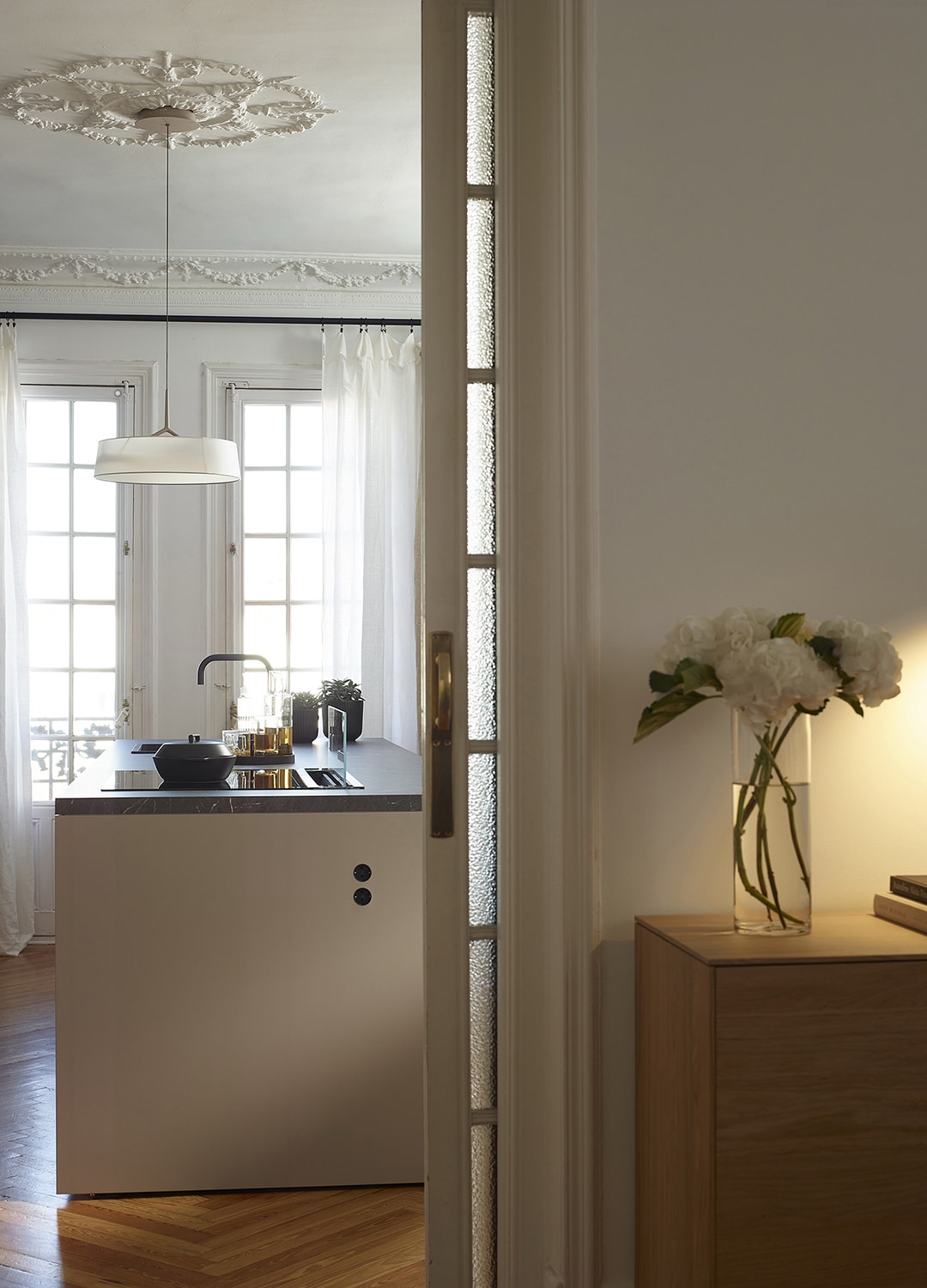 Detail van het eiland in de open keuken naar de zitkamer met meubilair uit de nieuwe Living-lijn van Santos.