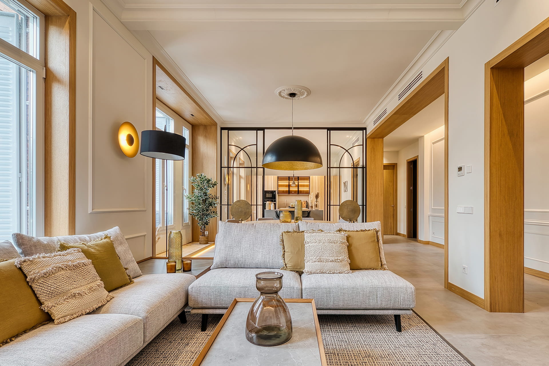 Vista de una vivienda con cocina en madera y cerramiento acristalado diseñada por Santos.