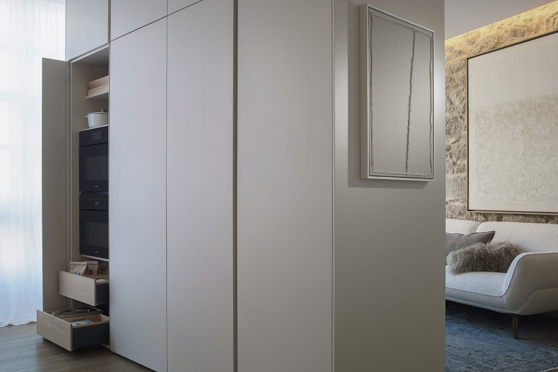 Armarios blancos de cocina en columna con puertas escamoteables en un diseño de Cocinas Santos.