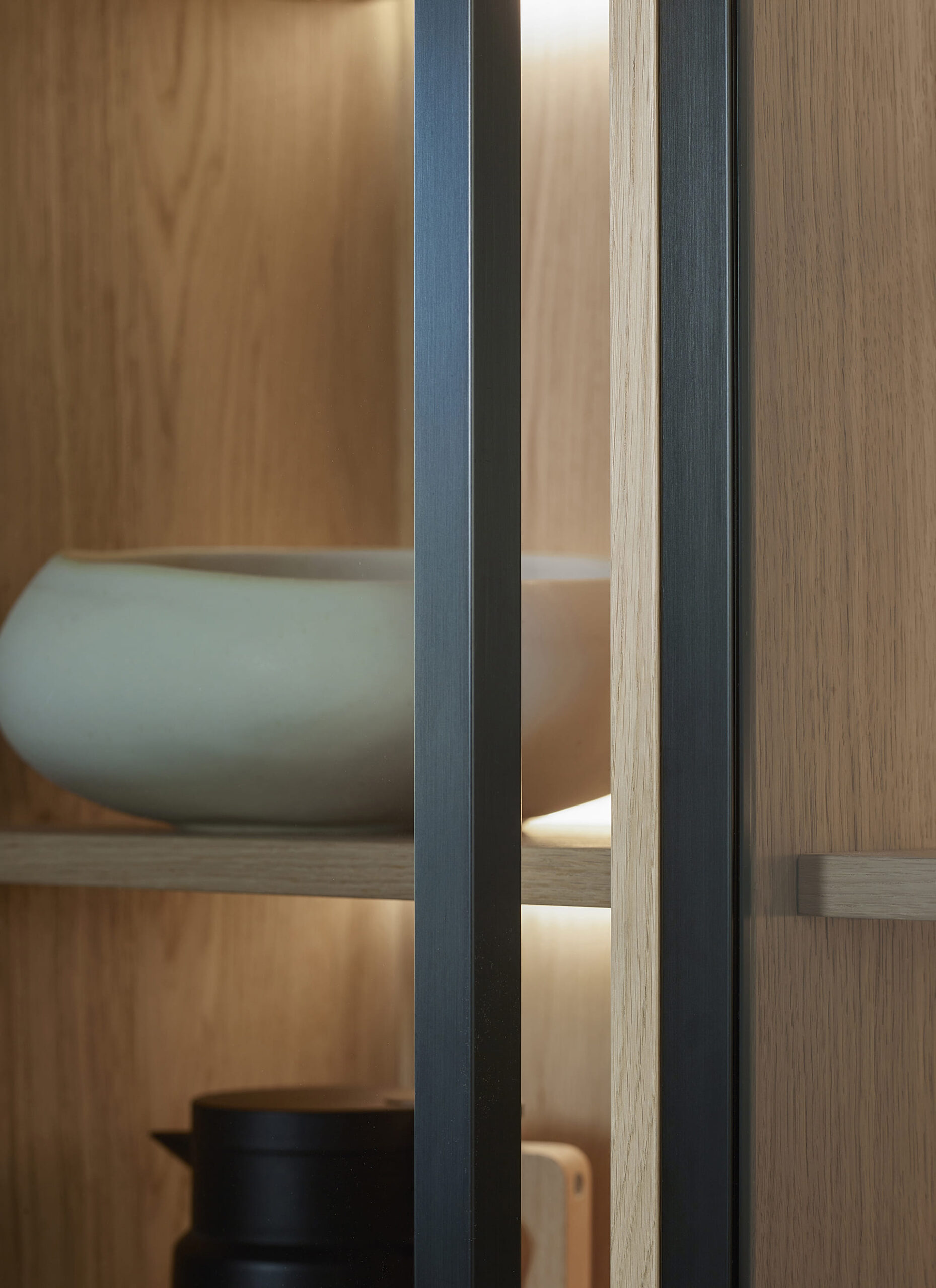 Detalle de las vitrinas con iluminación interior en el salón con muebles de Santos.
