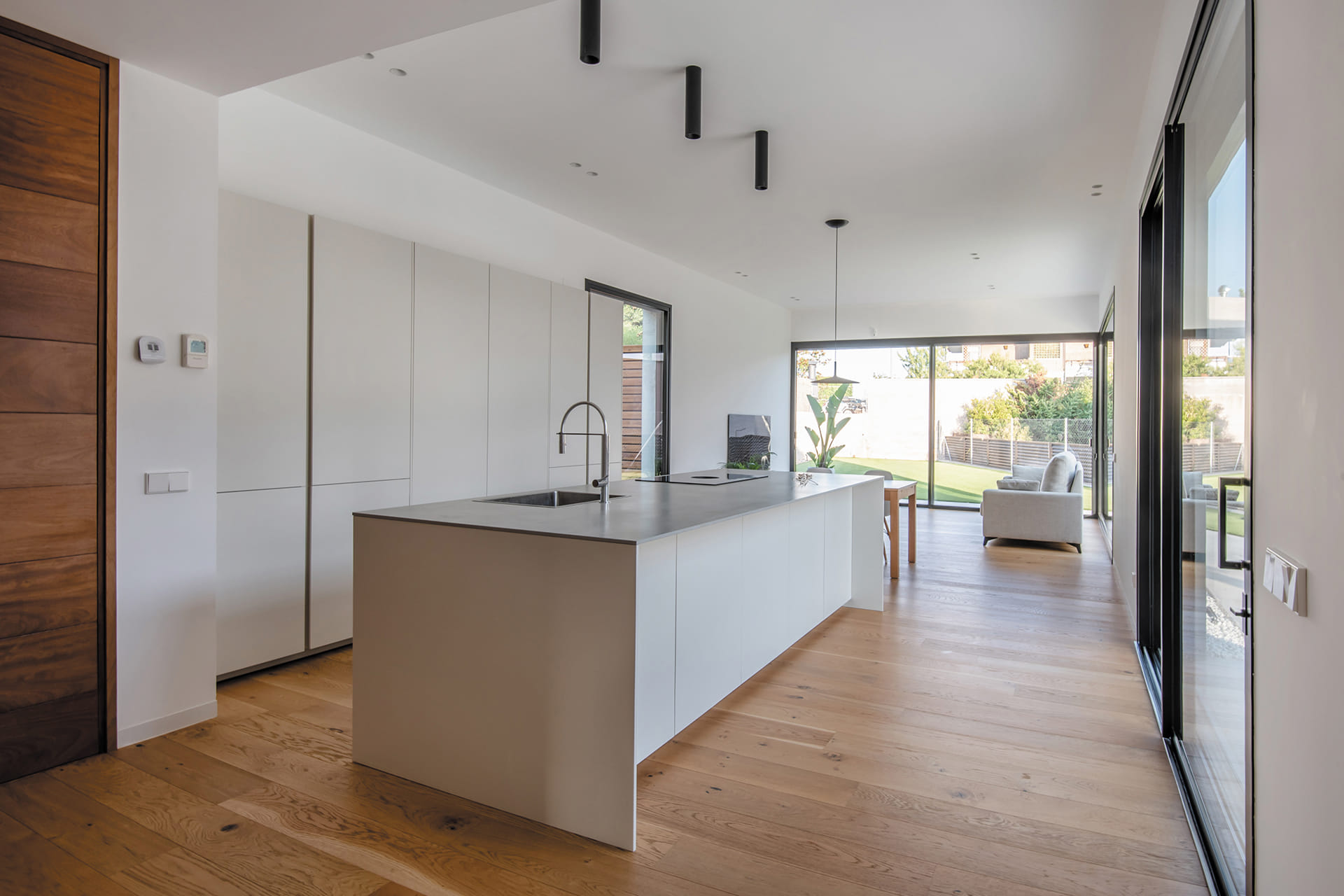Cocina abierta al salón con muebles en color Blanco Perla diseñada por cocinas Santos.