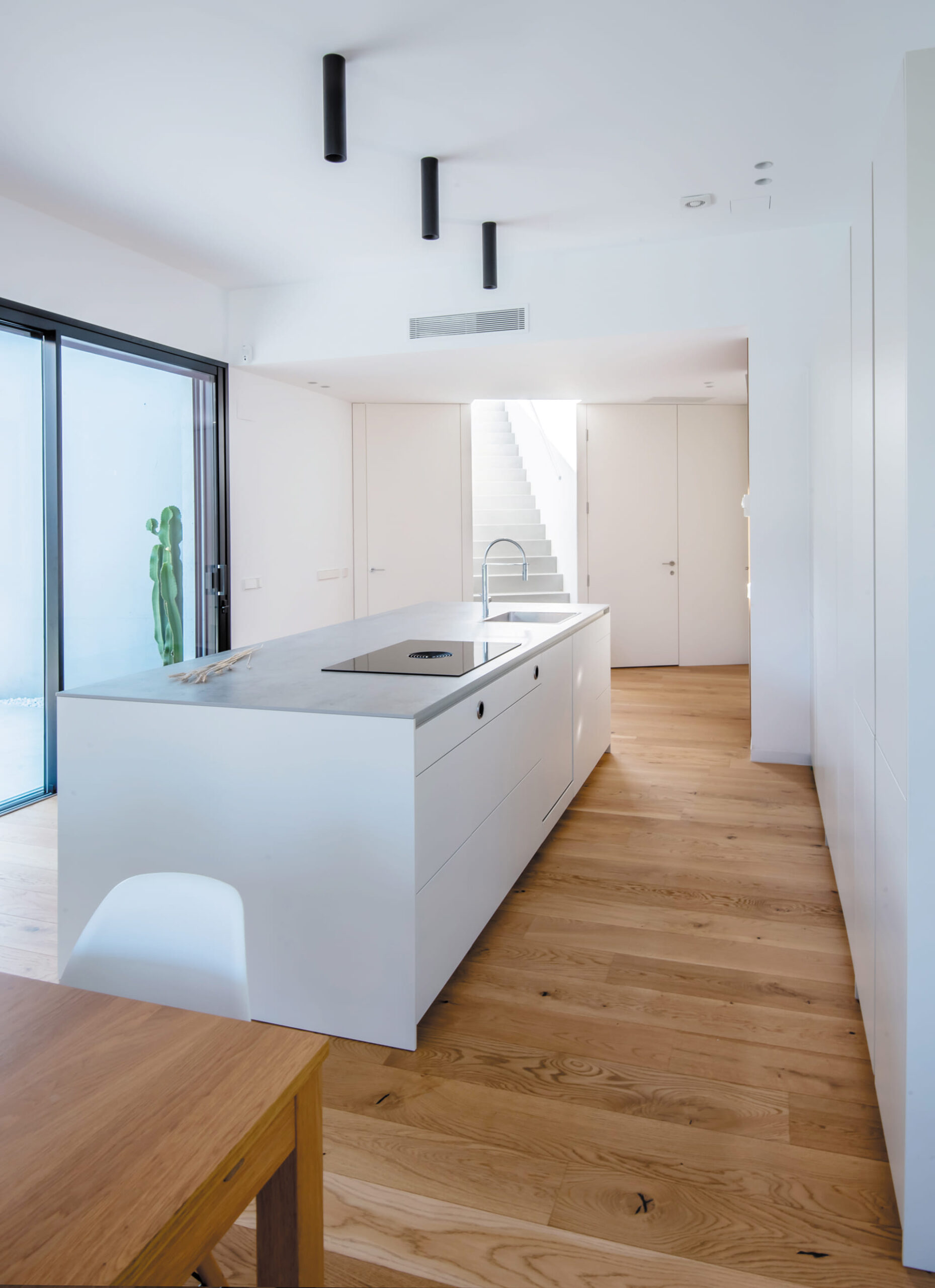 Cocina blanca con isla de cocina central en color Blanco Perla de Santos.