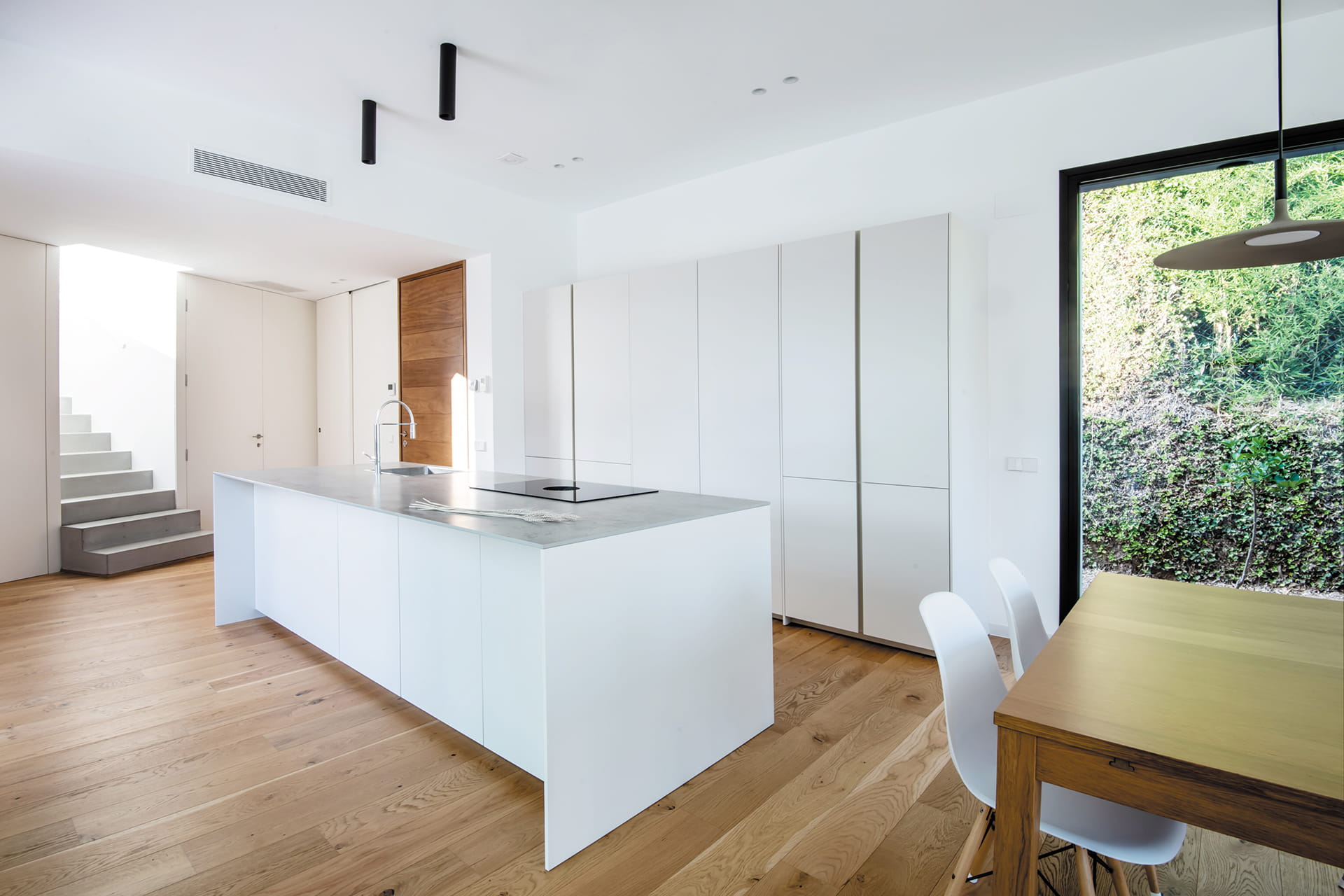 Cocina con isla abierta al salón en un proyecto de Cocinas Santos.