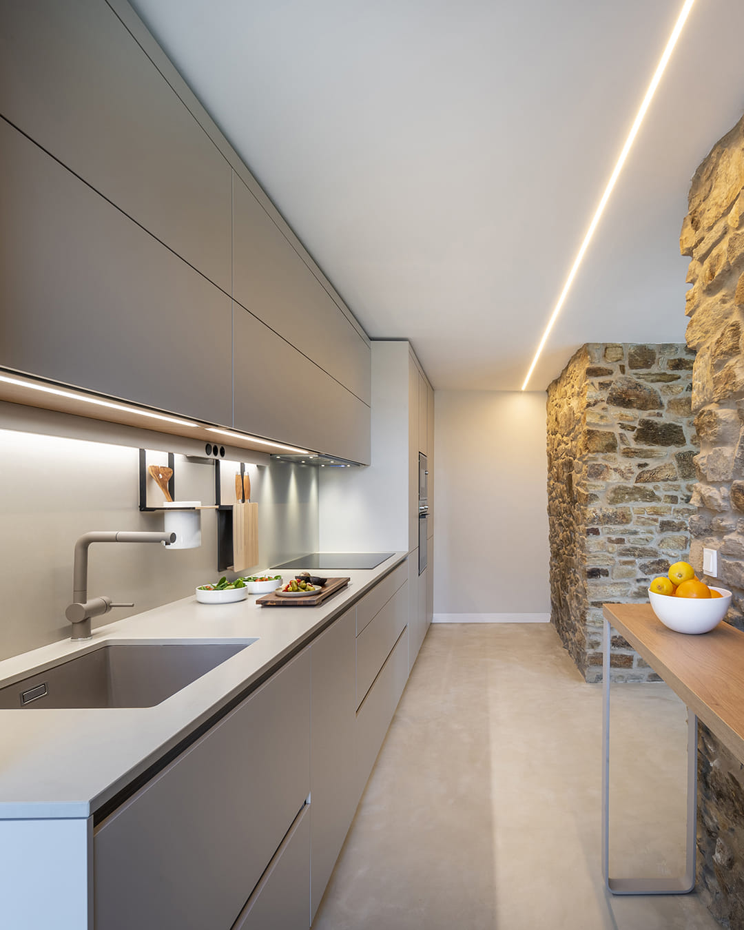 Cocina gris abierta en paralelo diseñada por Santos.