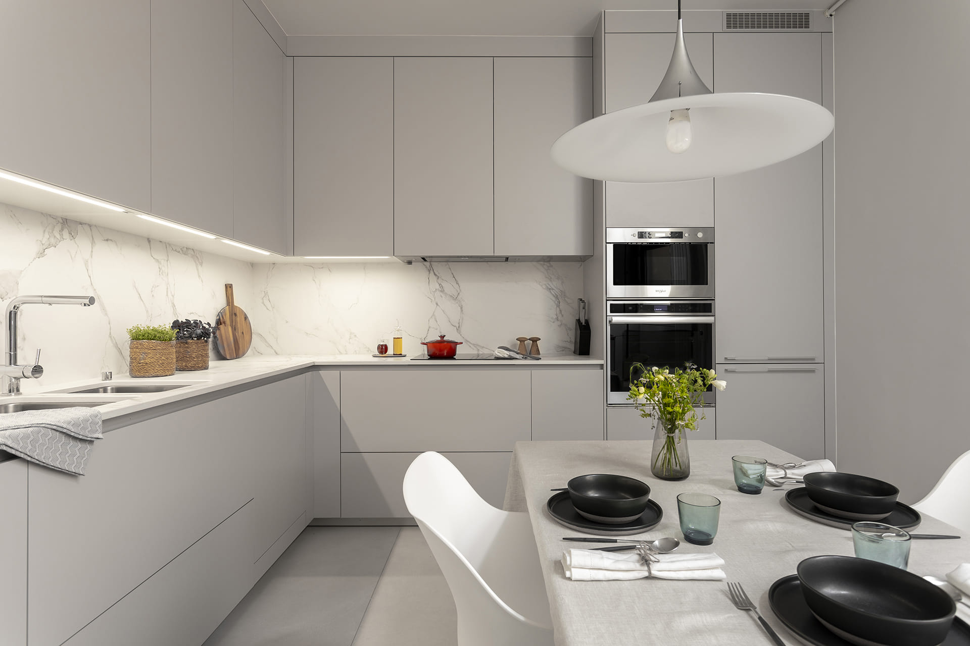Cocina gris en L con iluminación LED en un proyecto de Cocinas Santos.