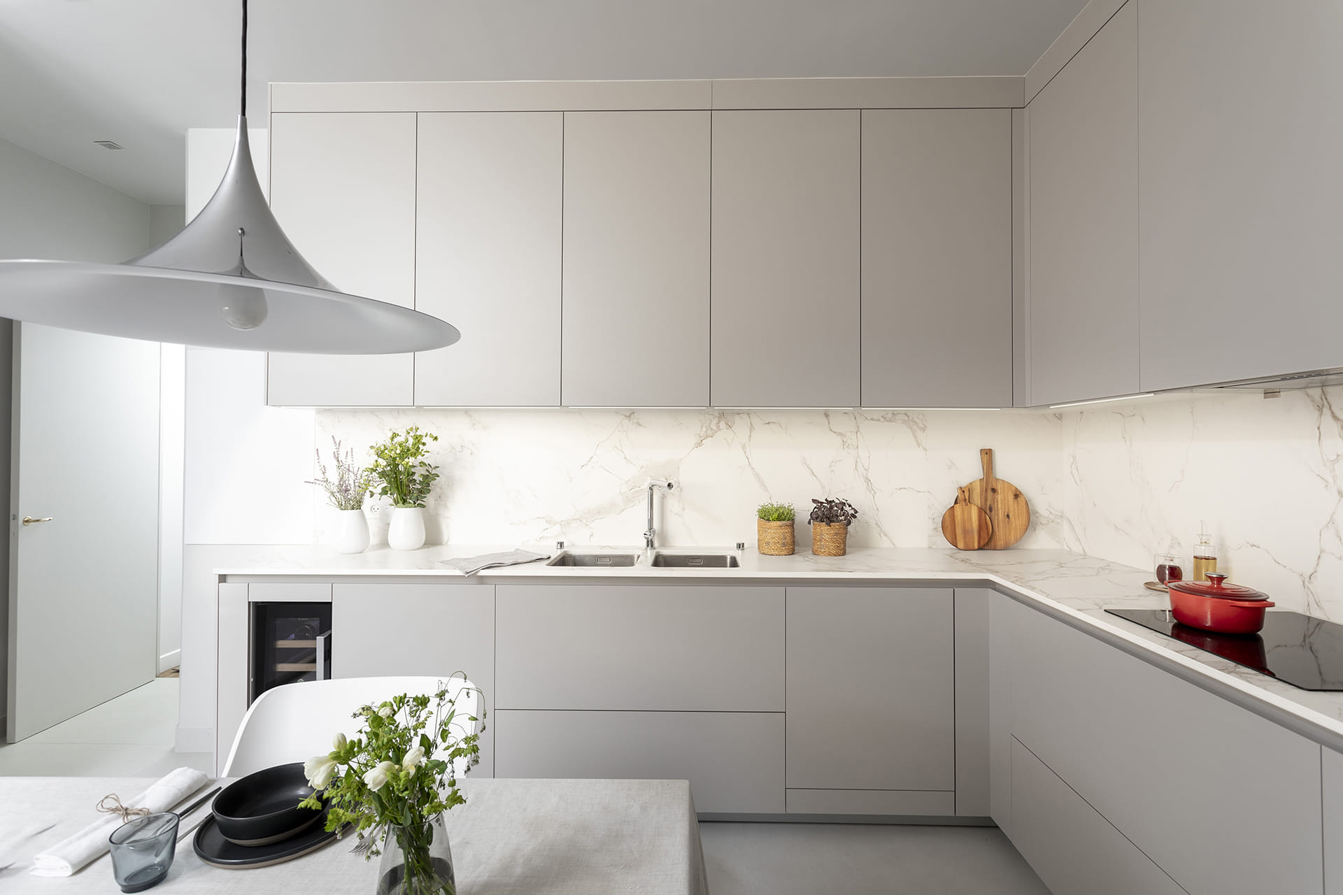 Cocina gris con office e iluminación sobre la encimera diseñada por Santos.