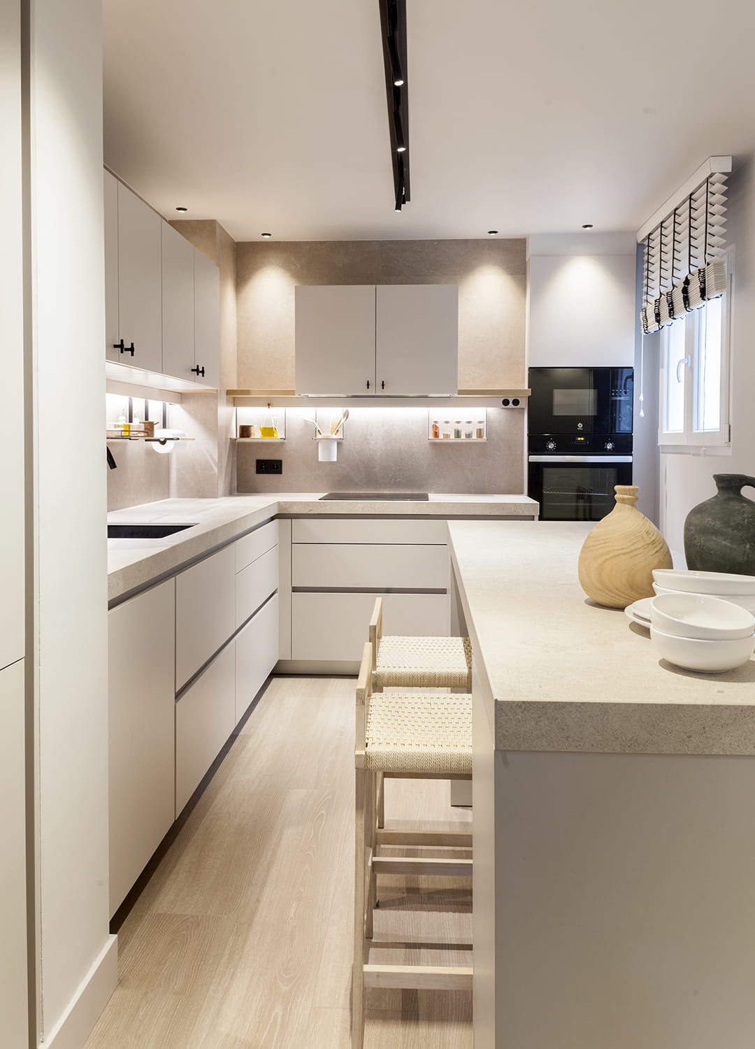 Cocina gris diseñada por Santos con perfiles de iluminación sobre la encimera.