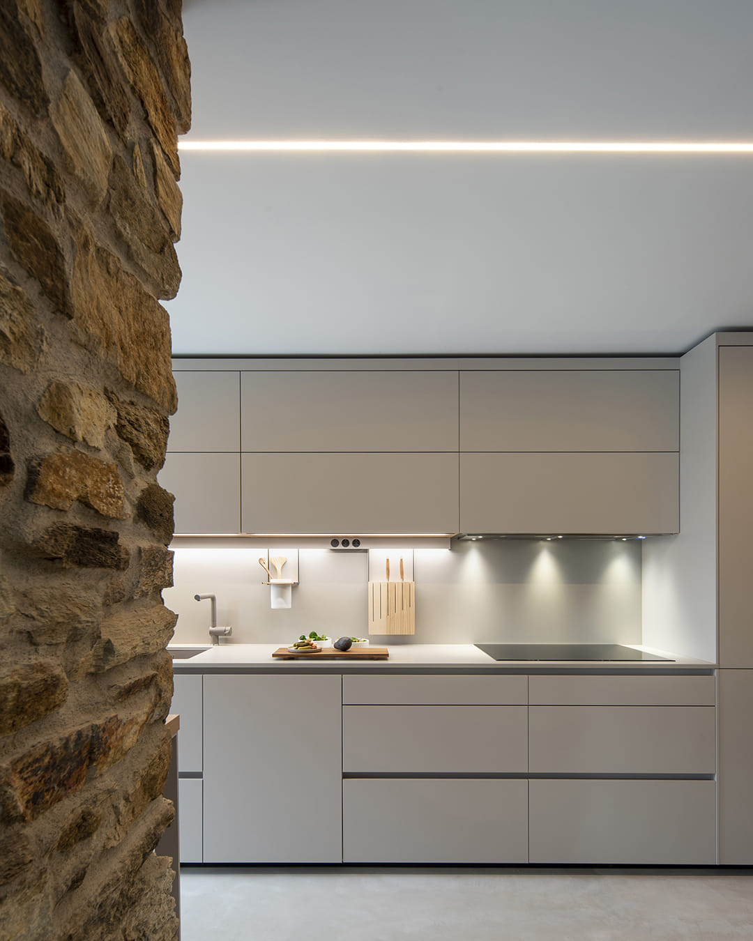 Cocina Santos con muebles altos y un perfil de iluminación LED sobre la encimera.