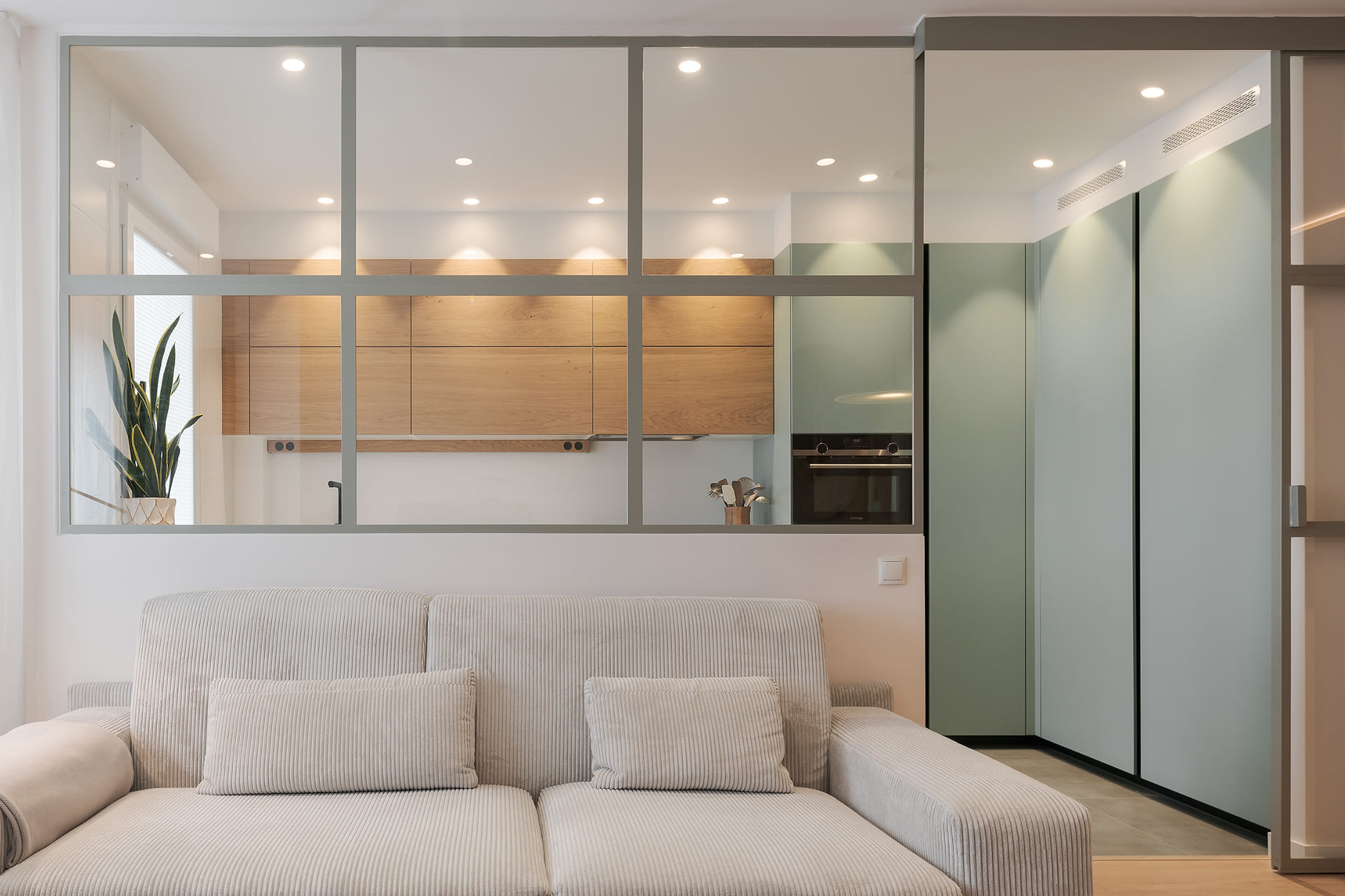 Cocina verde con cerramiento de cristal diseñada por Santos.