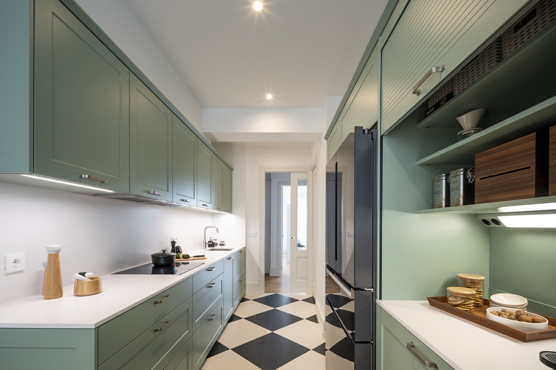 Cocina verde de Santos con distribución en paralelo y perfiles de iluminación integrados.
