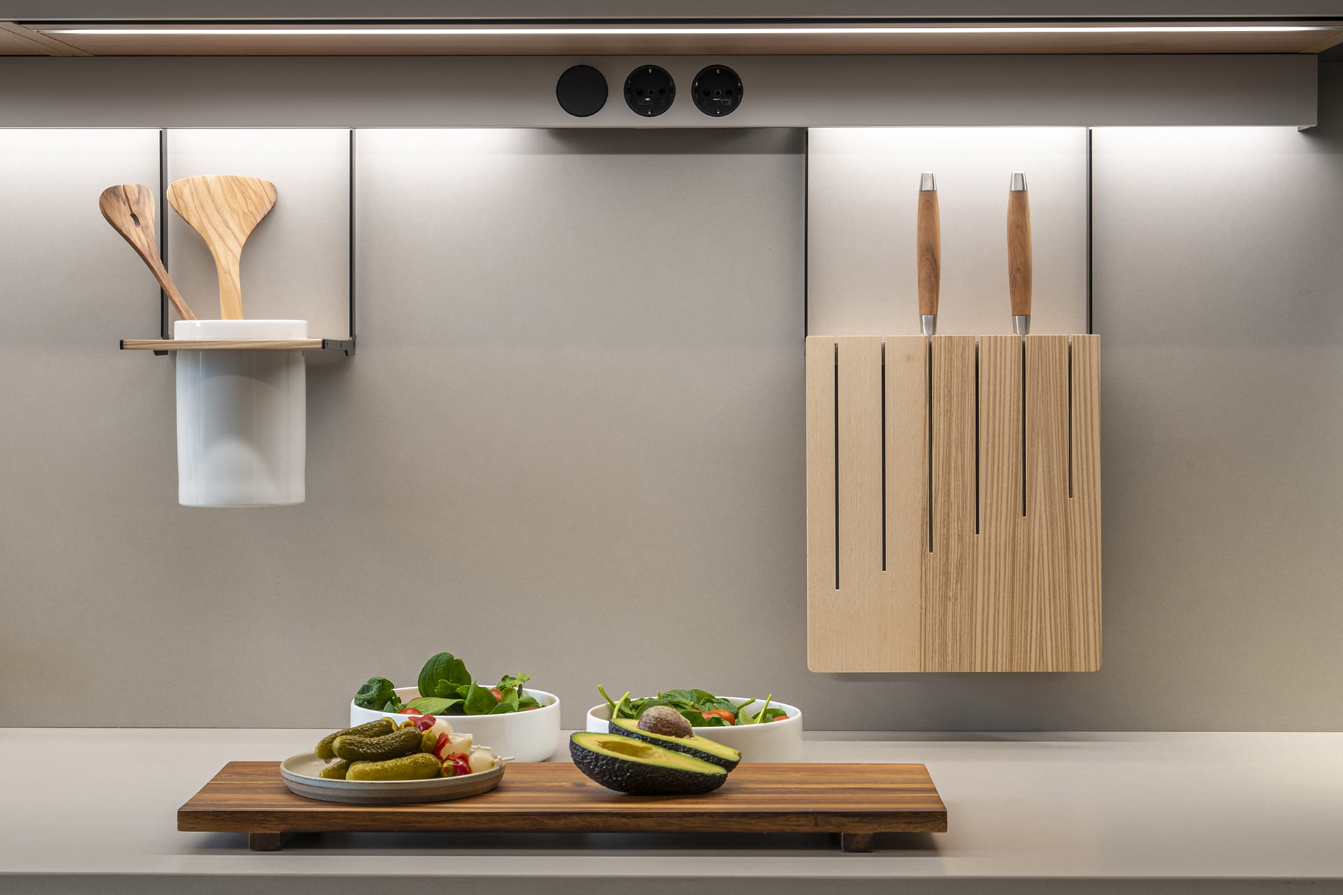 Encimera de cocina con perfil de iluminación y tomas de corriente en un proyecto de Santos.