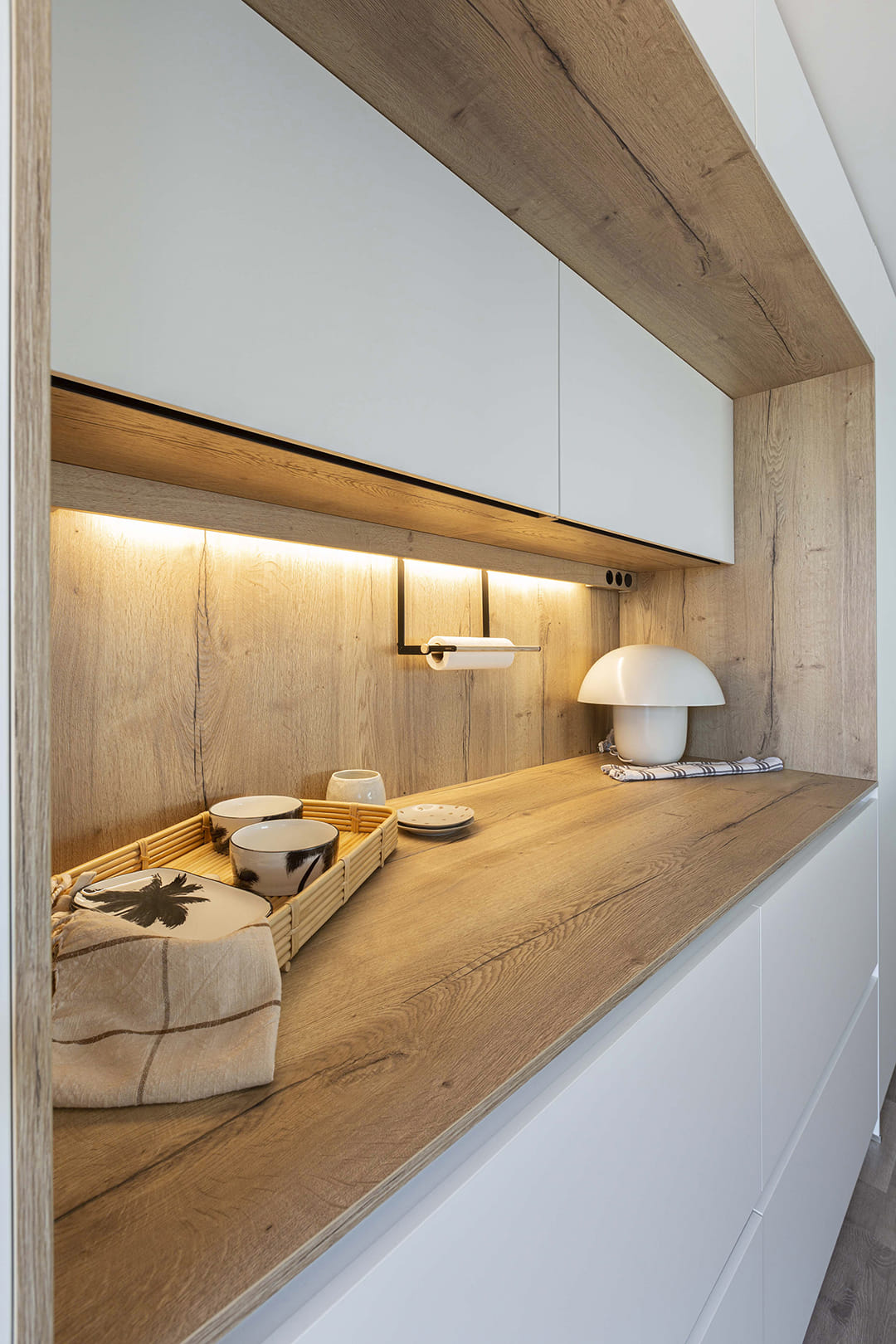Encimera de madera en una cocina Santos con iluminación LED integrada en los muebles.