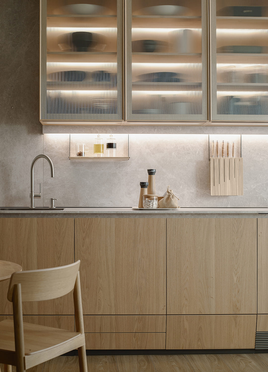 Vista frontal de uma cozinha em cor de madeira e painel laminado com acabamento em Quartzito Creme concebida pela Santos, cujo catálogo está disponível na Architonic.
