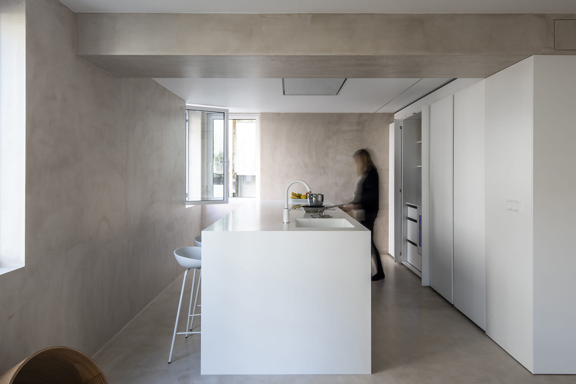 Cocina blanca de Santos con isla y muebles con puertas escamoteables.