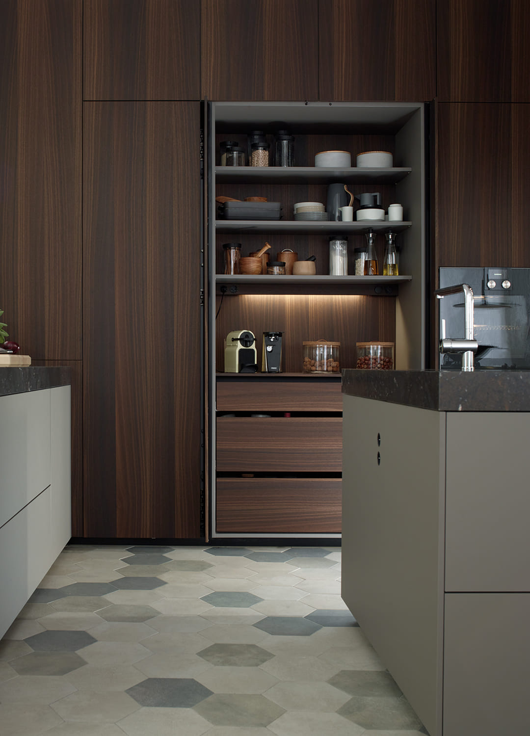 Armarios de cocina con iluminación interior y puertas escamoteables en un proyecto de Santos.