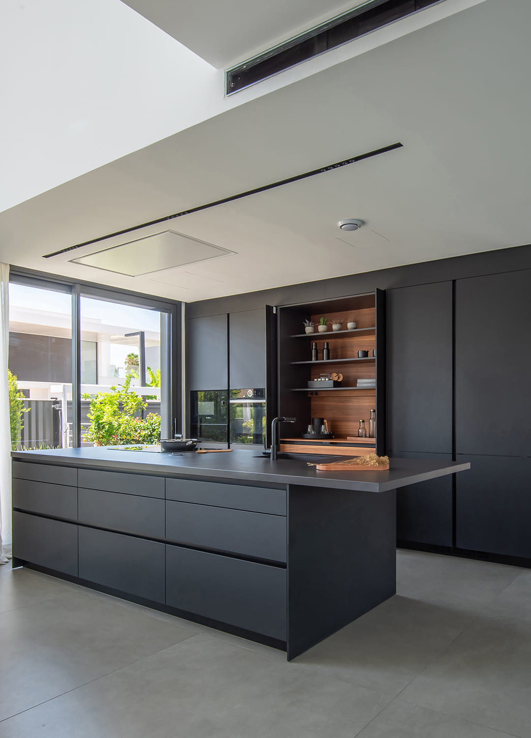Cocina negra Santos con armarios con puertas escamoteables.