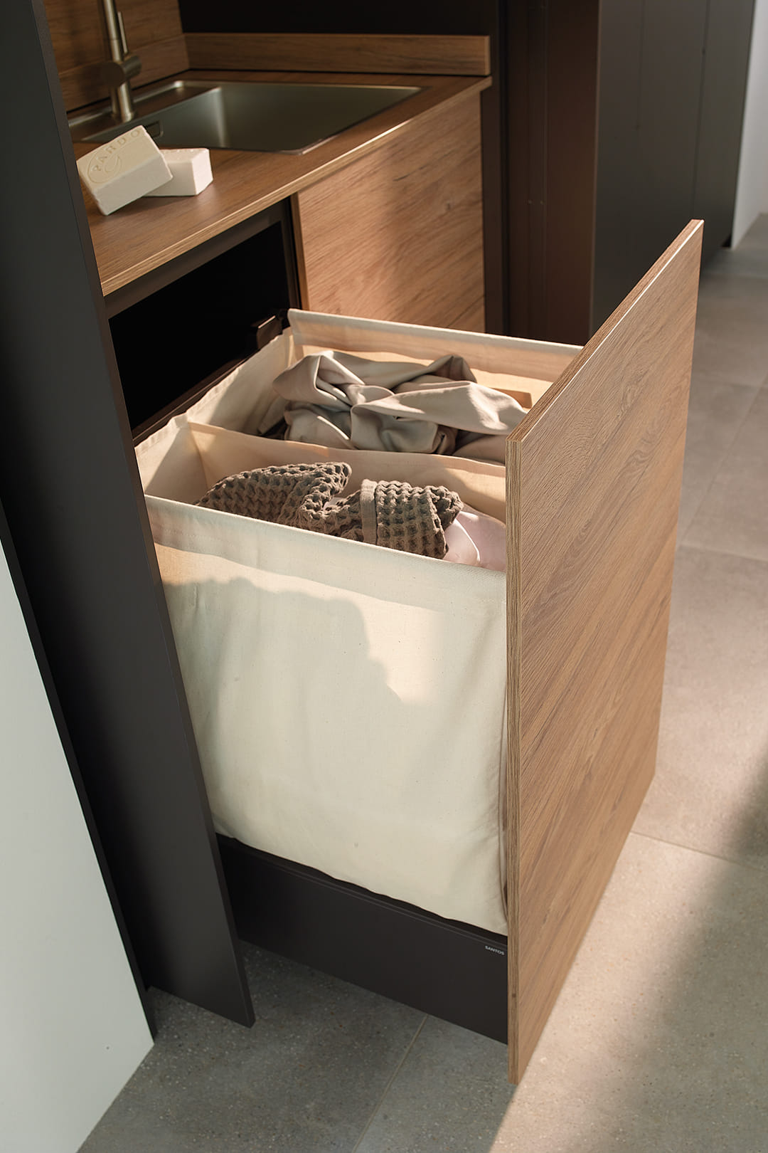 Cajoneras bajo el fregadero en un cuarto de lavado diseñado por Cocinas Santos.