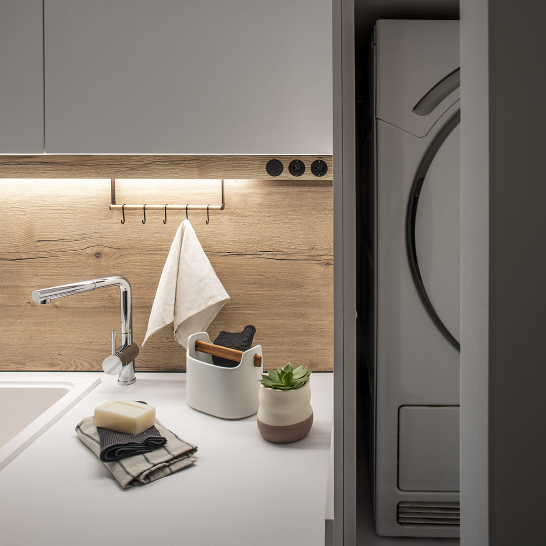 Detalle de cuarto de lavado con fregadero y armarios en columna diseñado por Cocinas Santos.