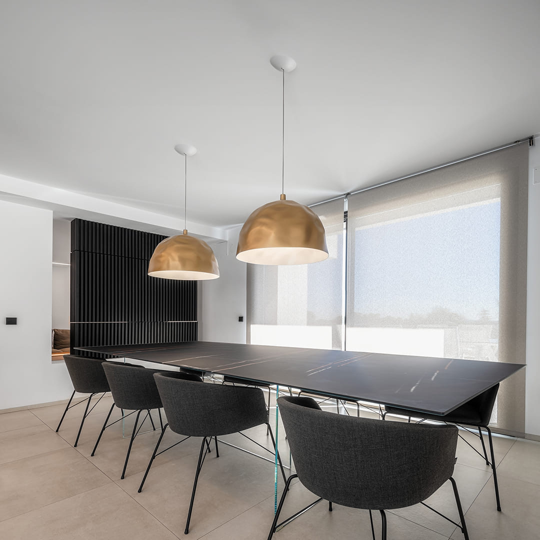 Black dining table in a black kitchen designed by Santos.