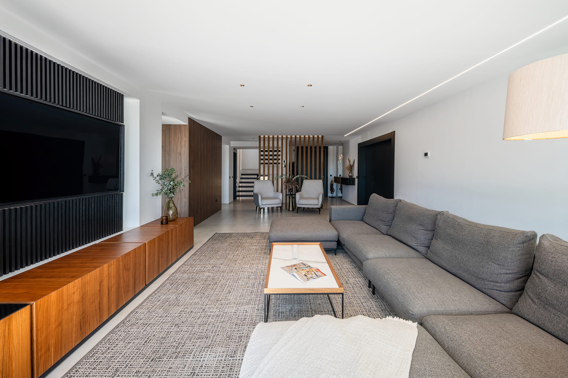 View of the lounge and staircase in a renovated house with a Santos kitchen.