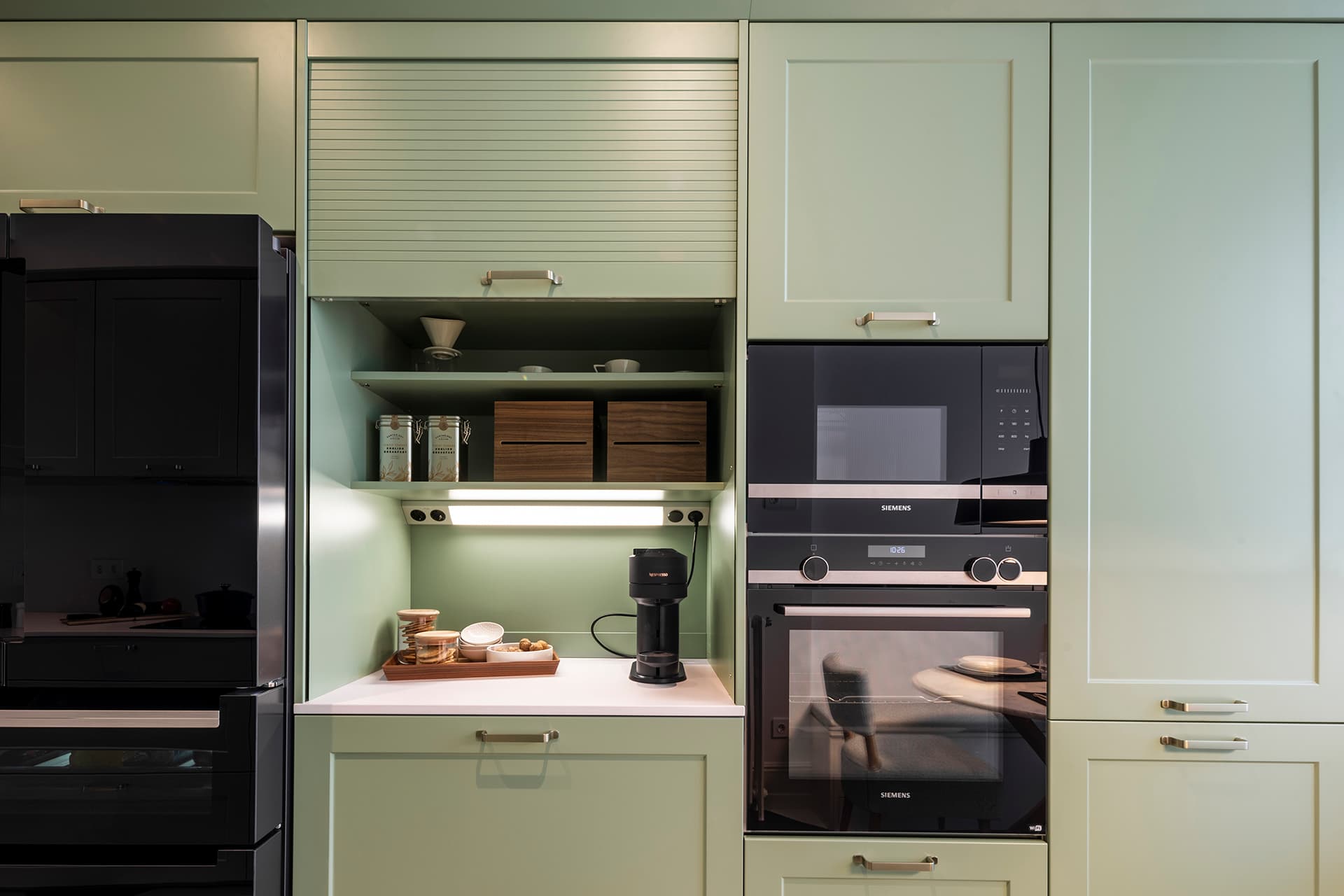 Tall units with integrated appliances in a Sage Green kitchen by Santos.