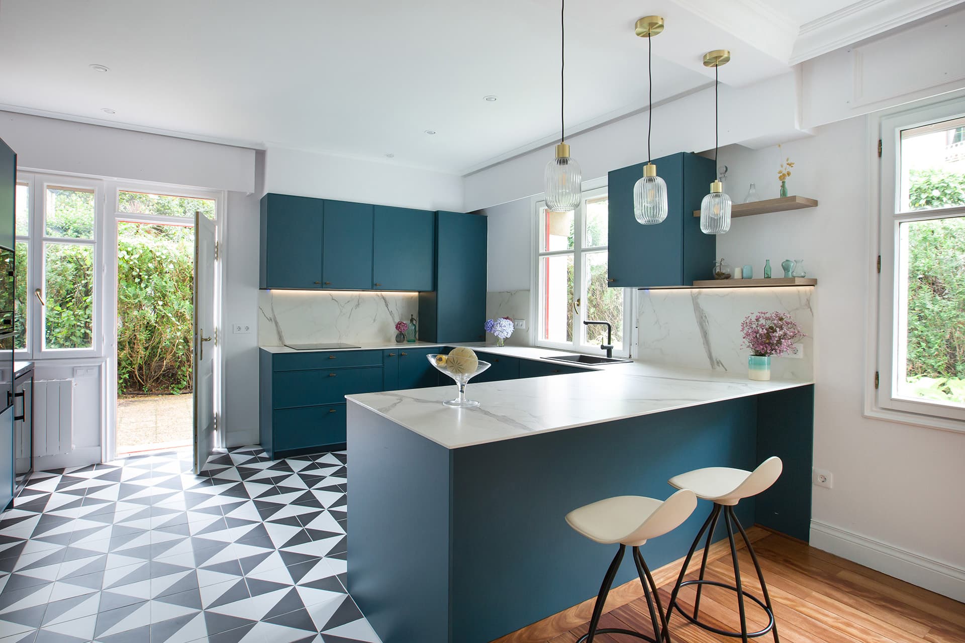 Blue kitchen open to the lounge designed by Santos Kitchens.