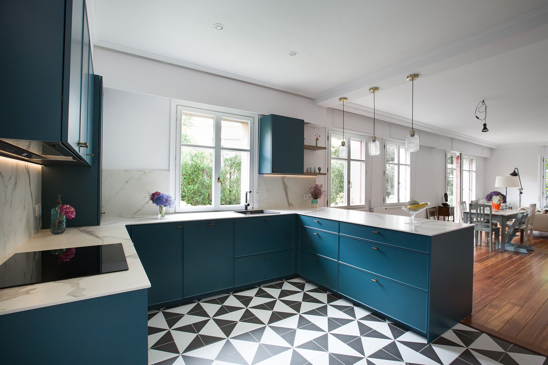 Blue kitchen with sink beneath the window designed by Santos Kitchens.