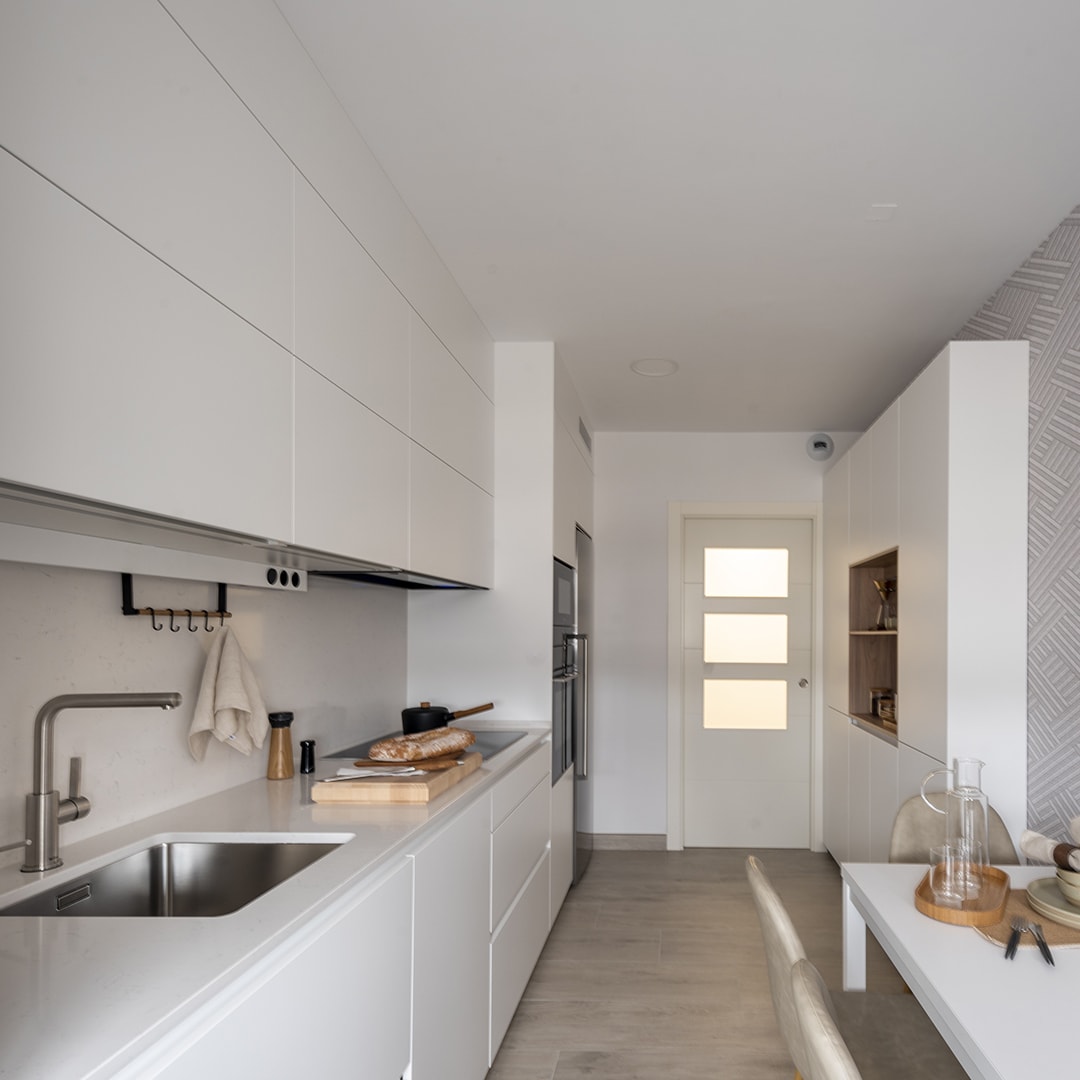 Kleine witte keuken van Santos in parallelle opstelling met officegedeelte.