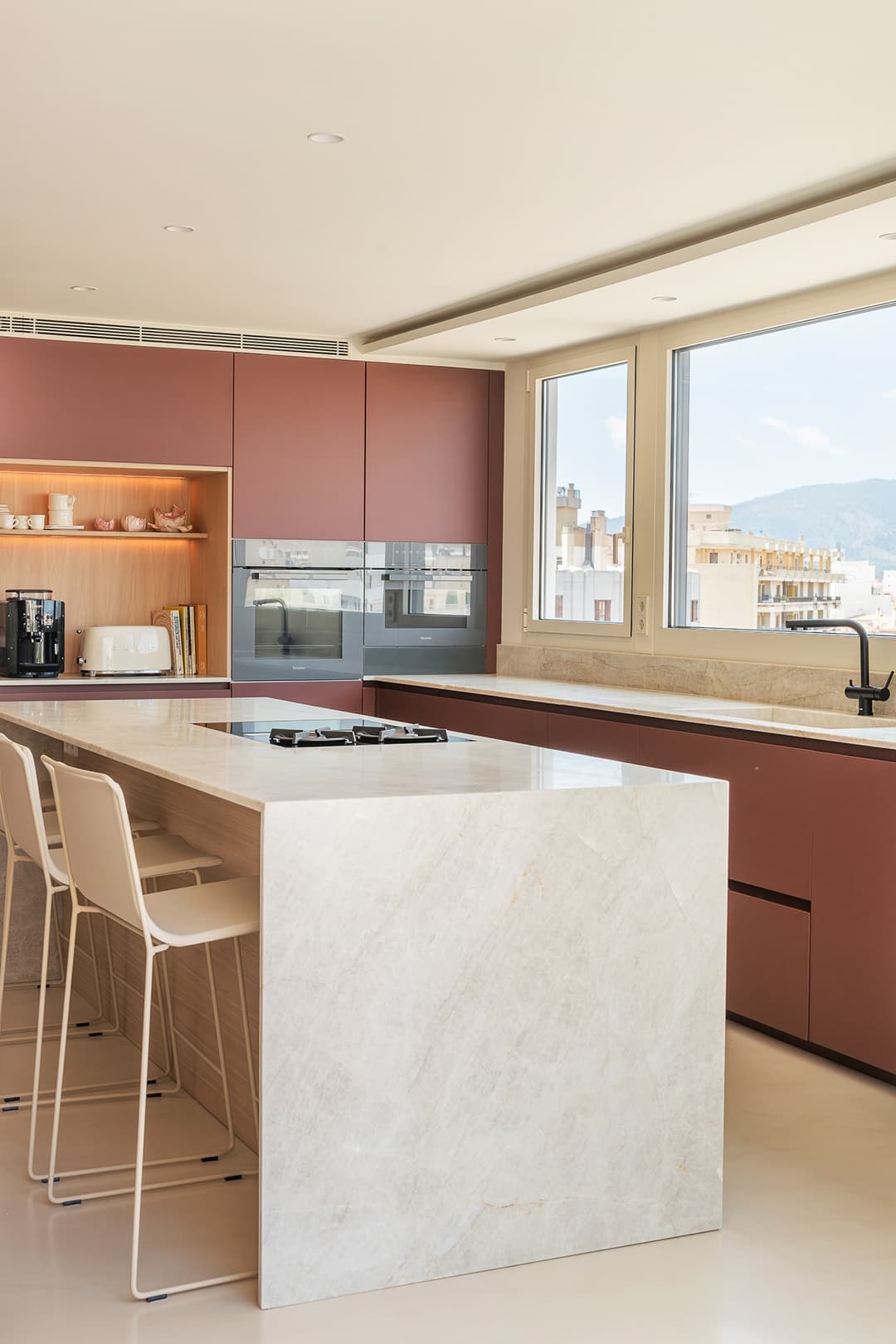 Kitchen island with ceramic hob in a red kitchen designed by Santos Kitchens.