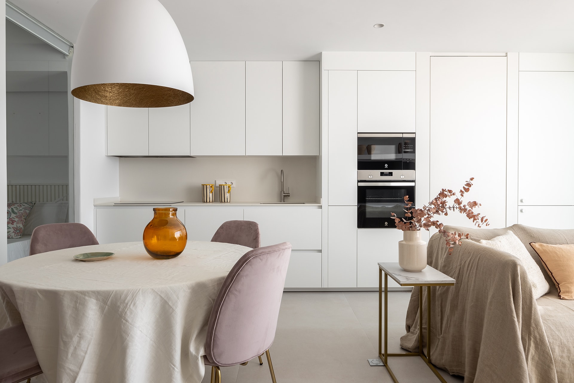 Cocina blanca abierta al salón diseñada por Cocinas Santos.
