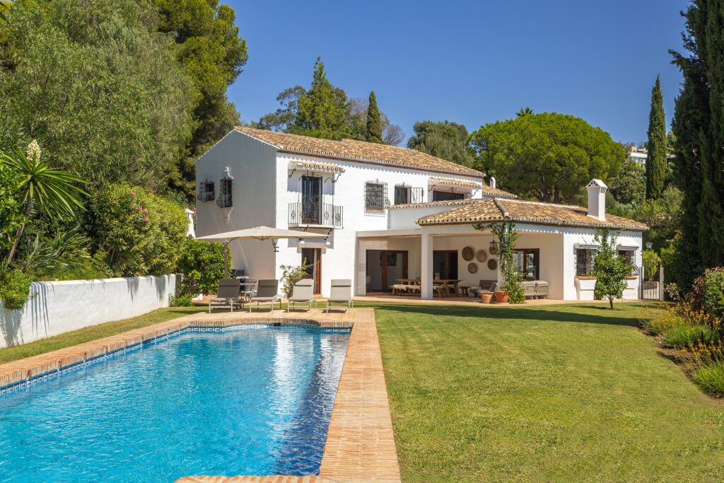 Vista exterior de vivienda unifamiliar con piscina que incluye una cocina diseñada por Santos.