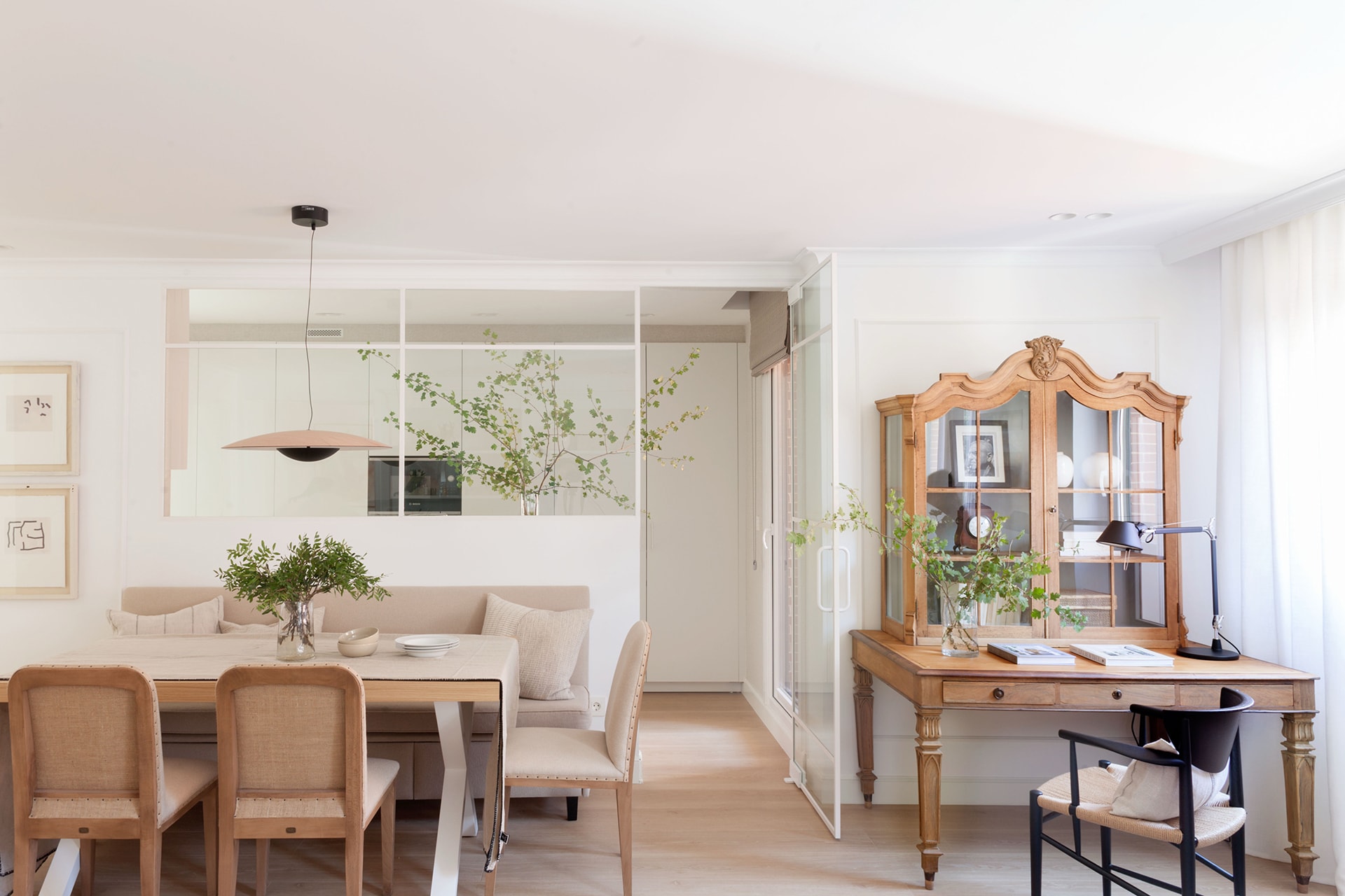 Kleine witte naar de woonkamer geopende keuken in een project van Santos.