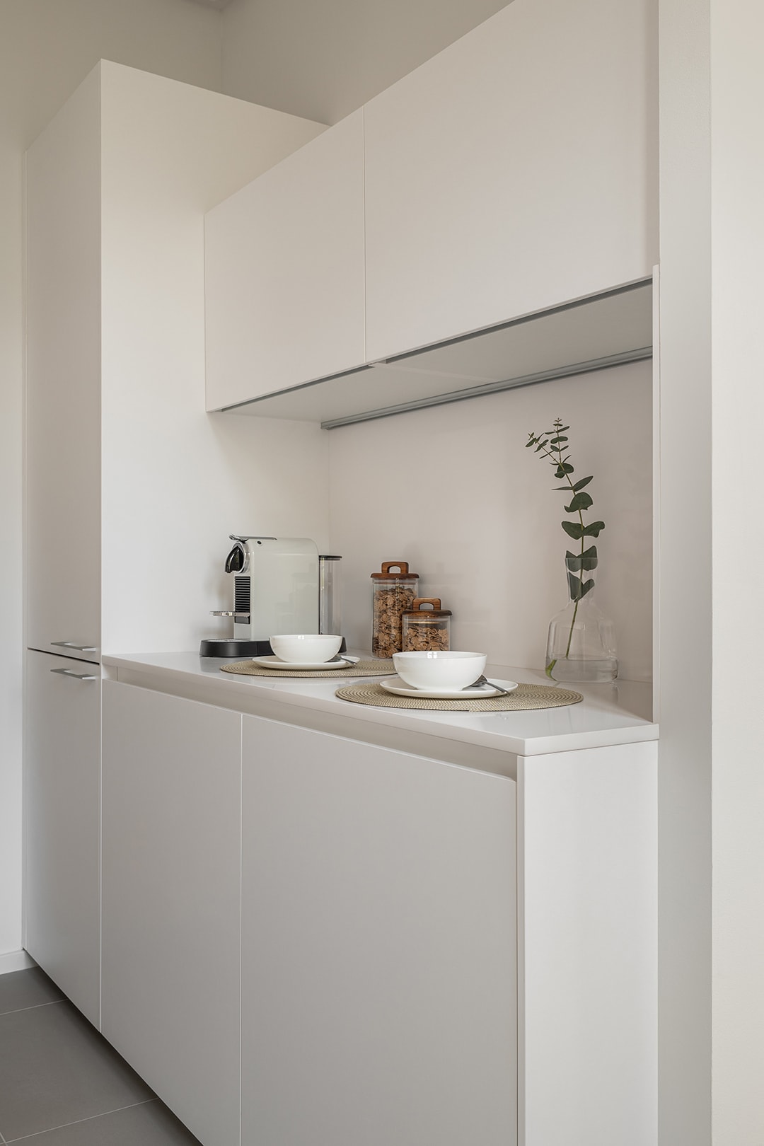 Detail van het officegedeelte in een kleine, naar de eetkamer geopende witte keuken.