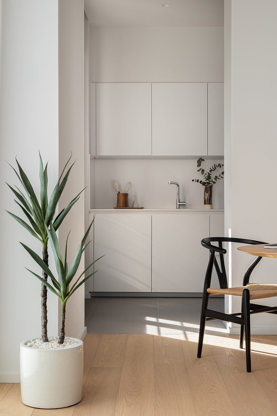 Spoelzone en kasten in een witte keuken van Santos vanuit de woonkamer gezien.