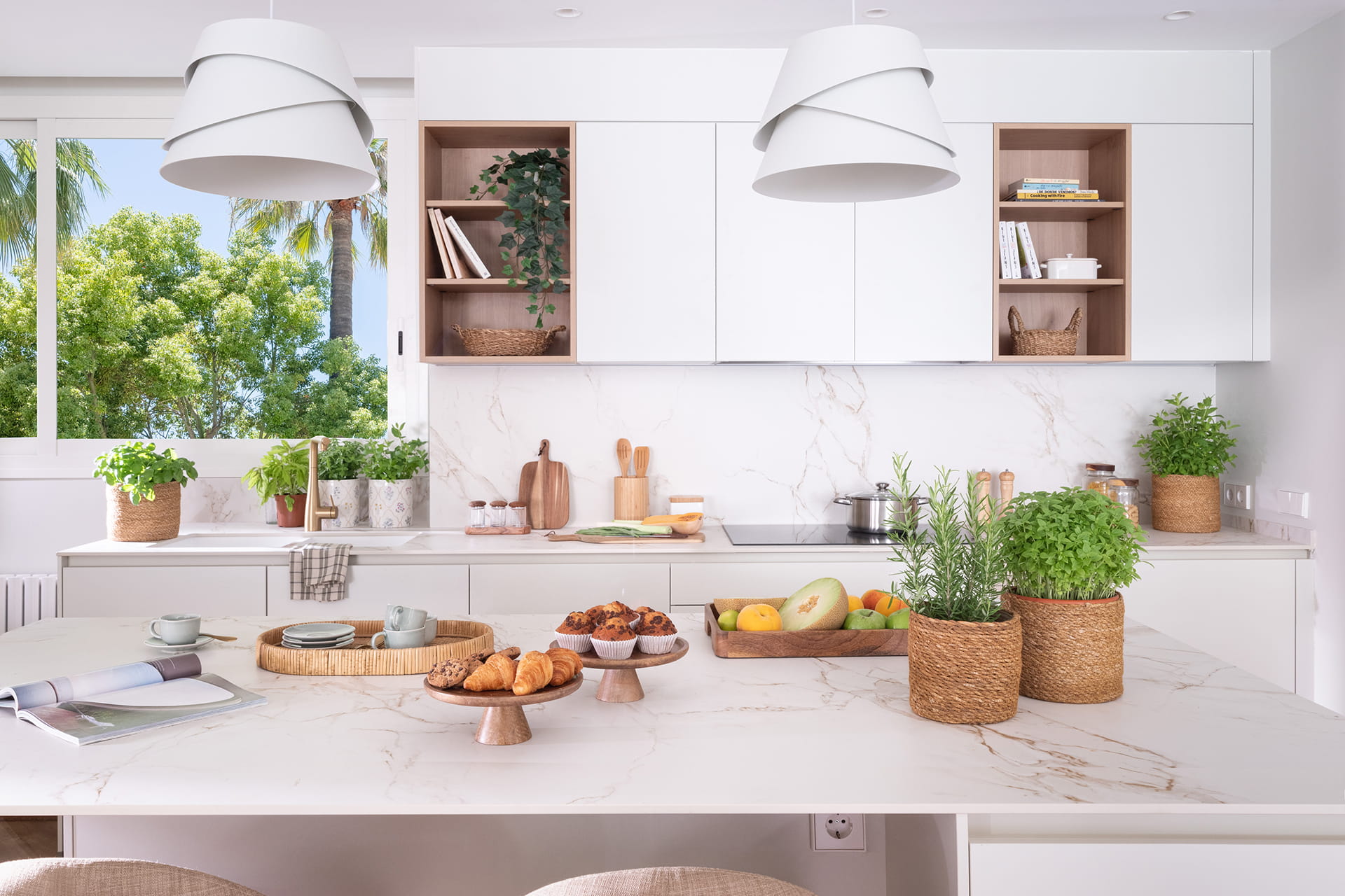 Cocina blanca con isla abierta hacia el salón y el comedor diseñada por Santos y Majo Flores.
