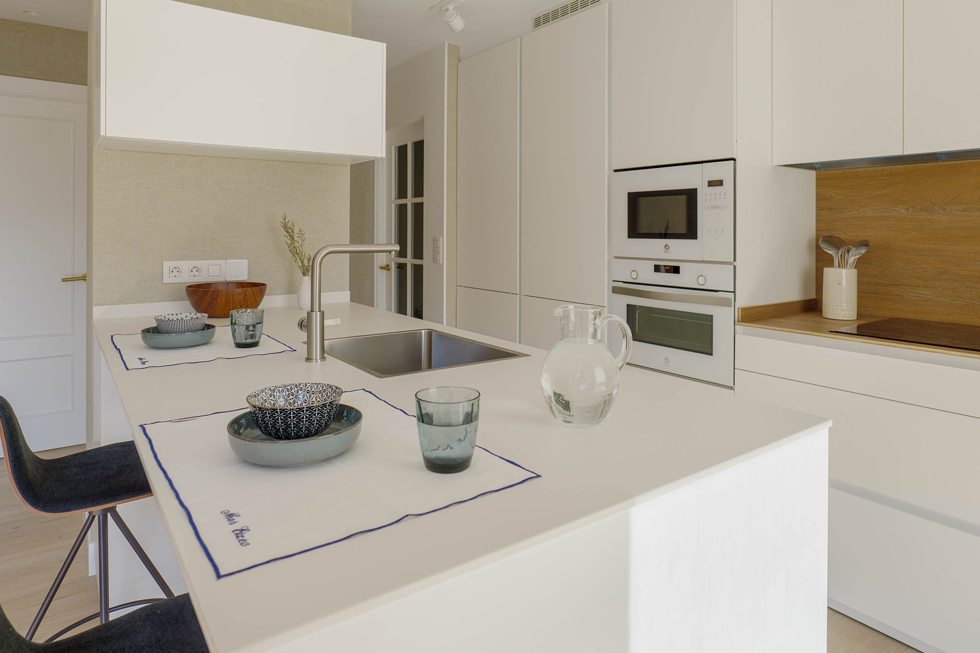 Cocina blanca y madera con península diseñada por Cocinas Santos.